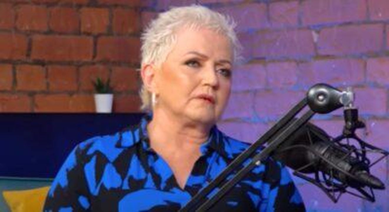 Segni_che_il_cancro_si_era_diffuso_al_cervello_nel_2023_92YZlP4Wrt - Confidenze24 source:entertainmentdaily - Segni che il cancro si era diffuso al cervello nel 2023 - Linda Nolan indossa una camicia blu e nera mentre parla in un microfono