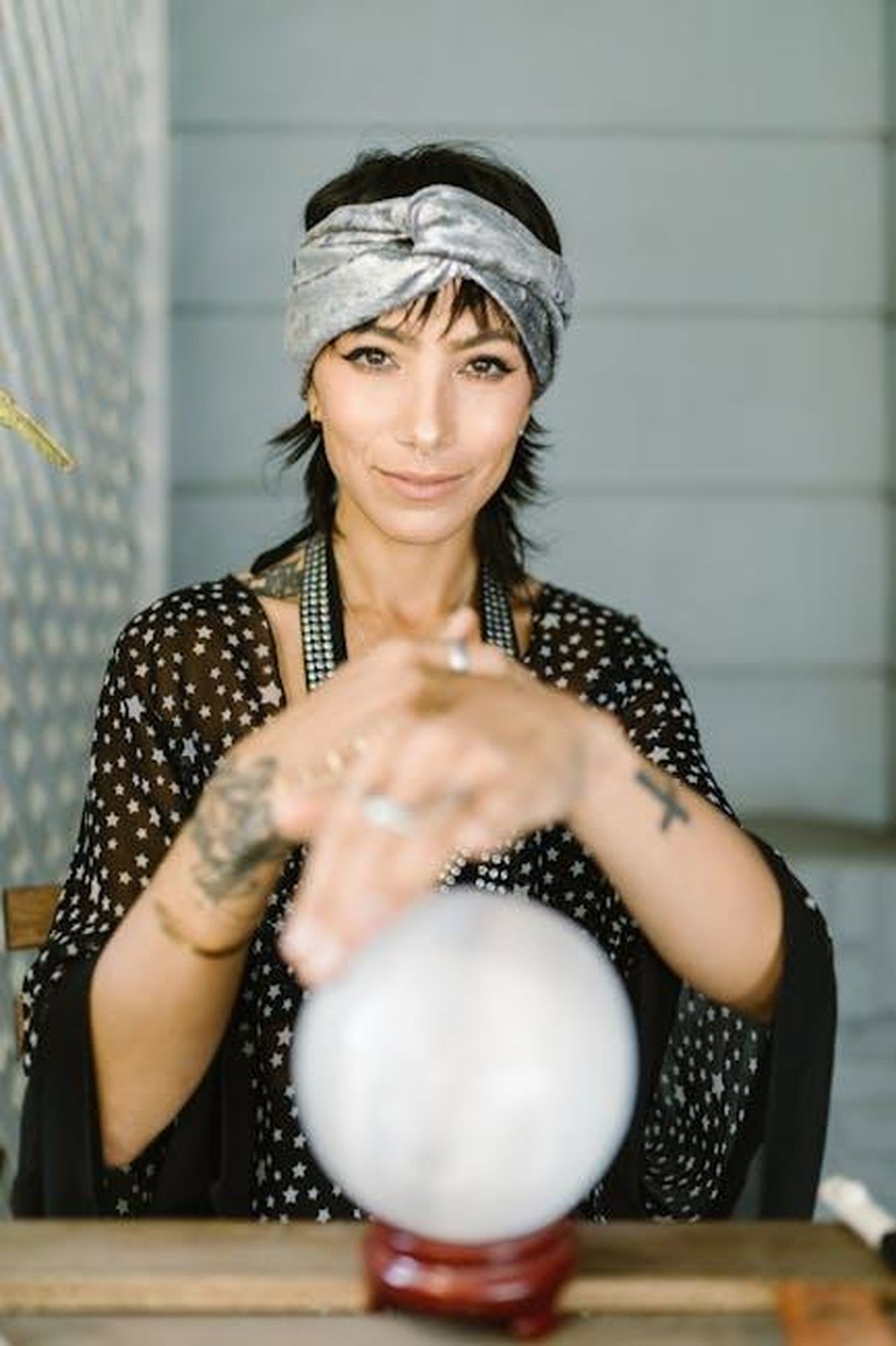 10_Bilancia_notizie_inattese_in_arrivo_yxScGeHRjY - Confidenze24 Source: RDNE Stock project - pexels - A woman with a headscarf and tattoos gazes over a crystal ball in a mystical setting.