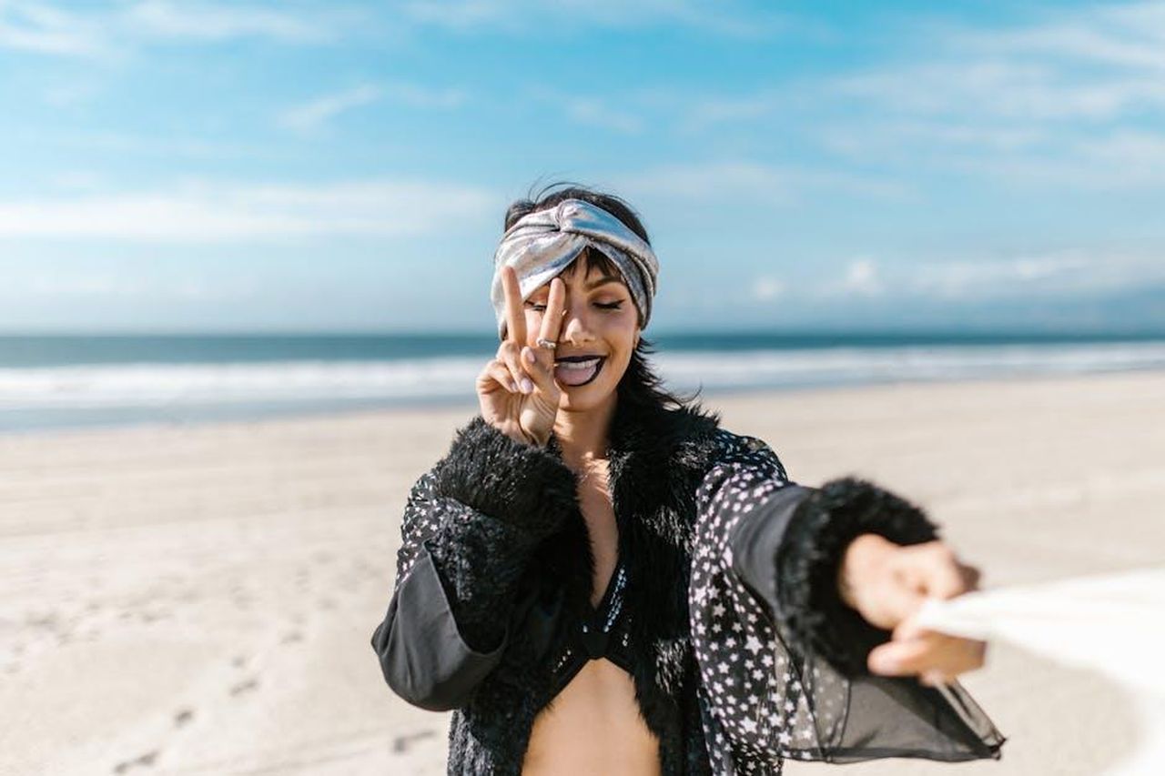 11_posto__Vergine_gUzt9C3n63 - Confidenze24 Source: RDNE Stock project - pexels - A woman having fun at the beach, showing a peace sign on a sunny day.