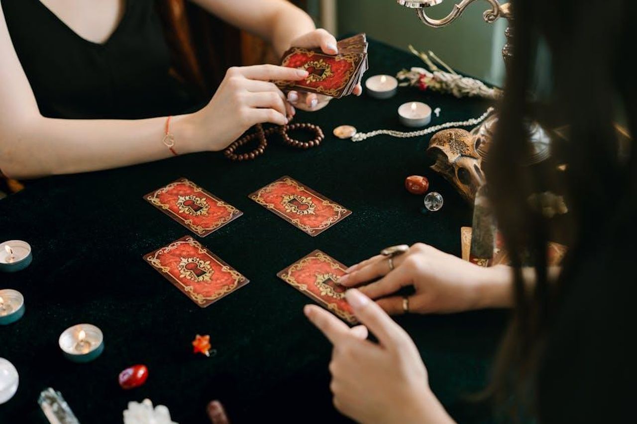 12_Bilancia_yXxInWp9x1 - Confidenze24 Source: Mikhail Nilov - pexels - A tarot card reading session with crystals and candles, creating a mystical atmosphere.