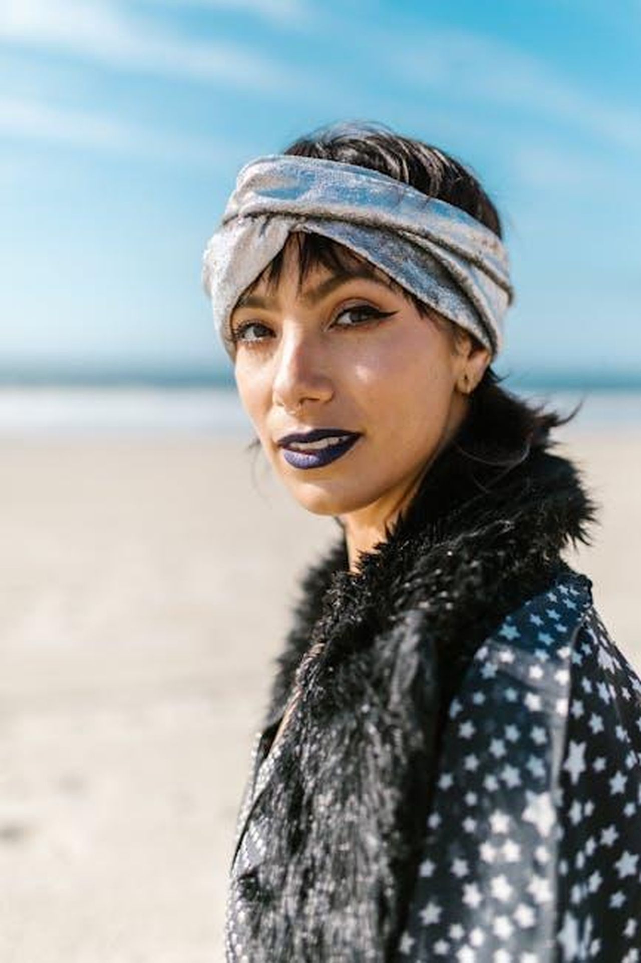 1_posto__Capricorno_6NglxxnRzy - Confidenze24 Source: RDNE Stock project - pexels - Woman in a patterned outfit and headscarf enjoys a sunny day at the beach.