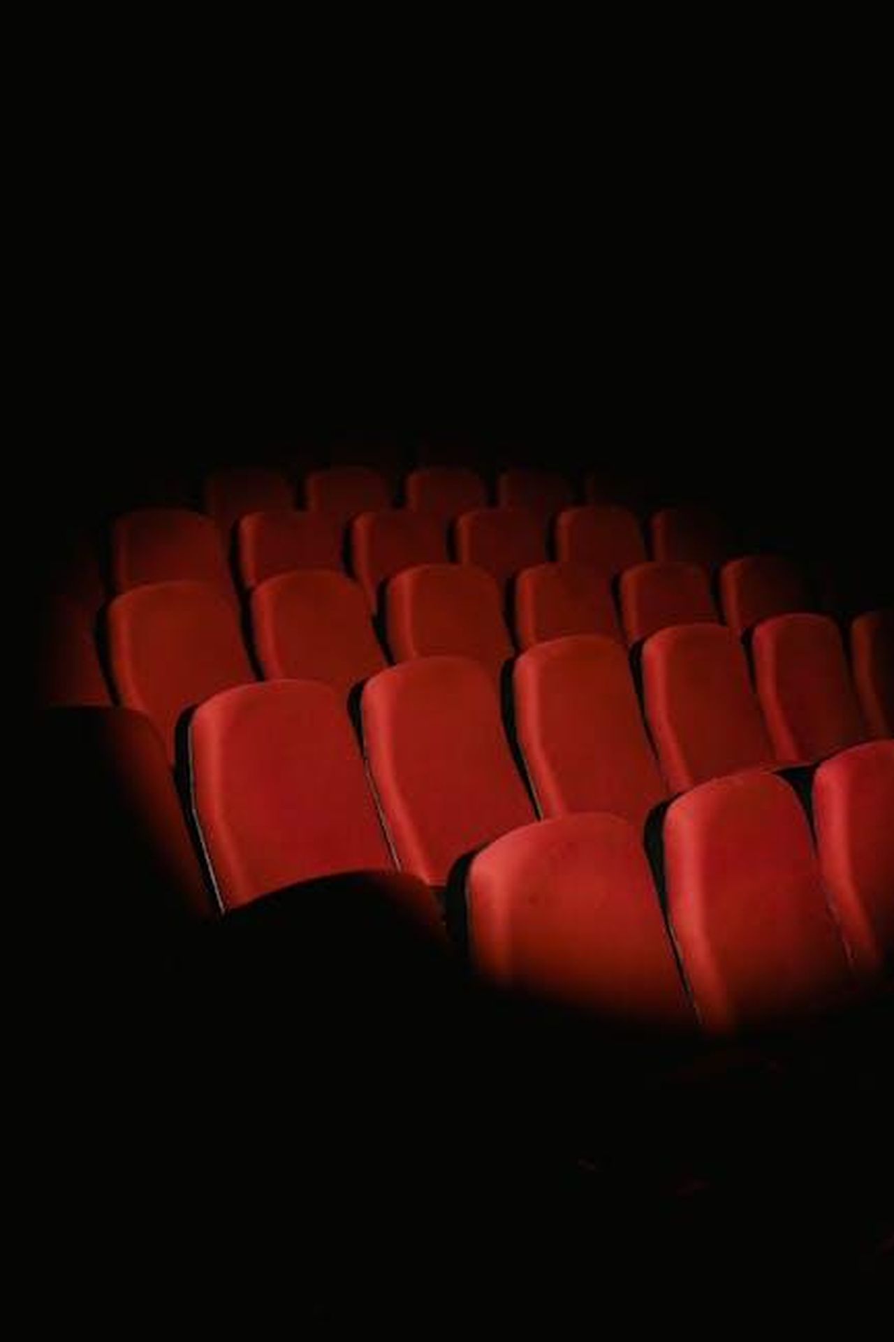 2014_Premiere_de_The_Imitation_Game_ZOguaQ4HWX - Confidenze24 Source: Tima Miroshnichenko - pexels - Rows of empty red seats in a dark movie theater creating a moody atmosphere.