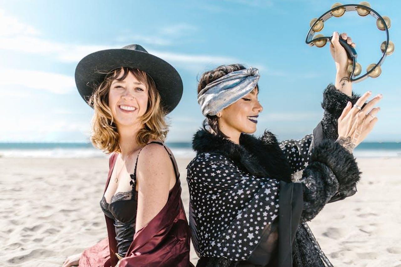 2_posto__Leone_MGjJKVJdDX - Confidenze24 Source: RDNE Stock project - pexels - Joyful women at the beach with a tambourine, embracing boho and mystical vibes.