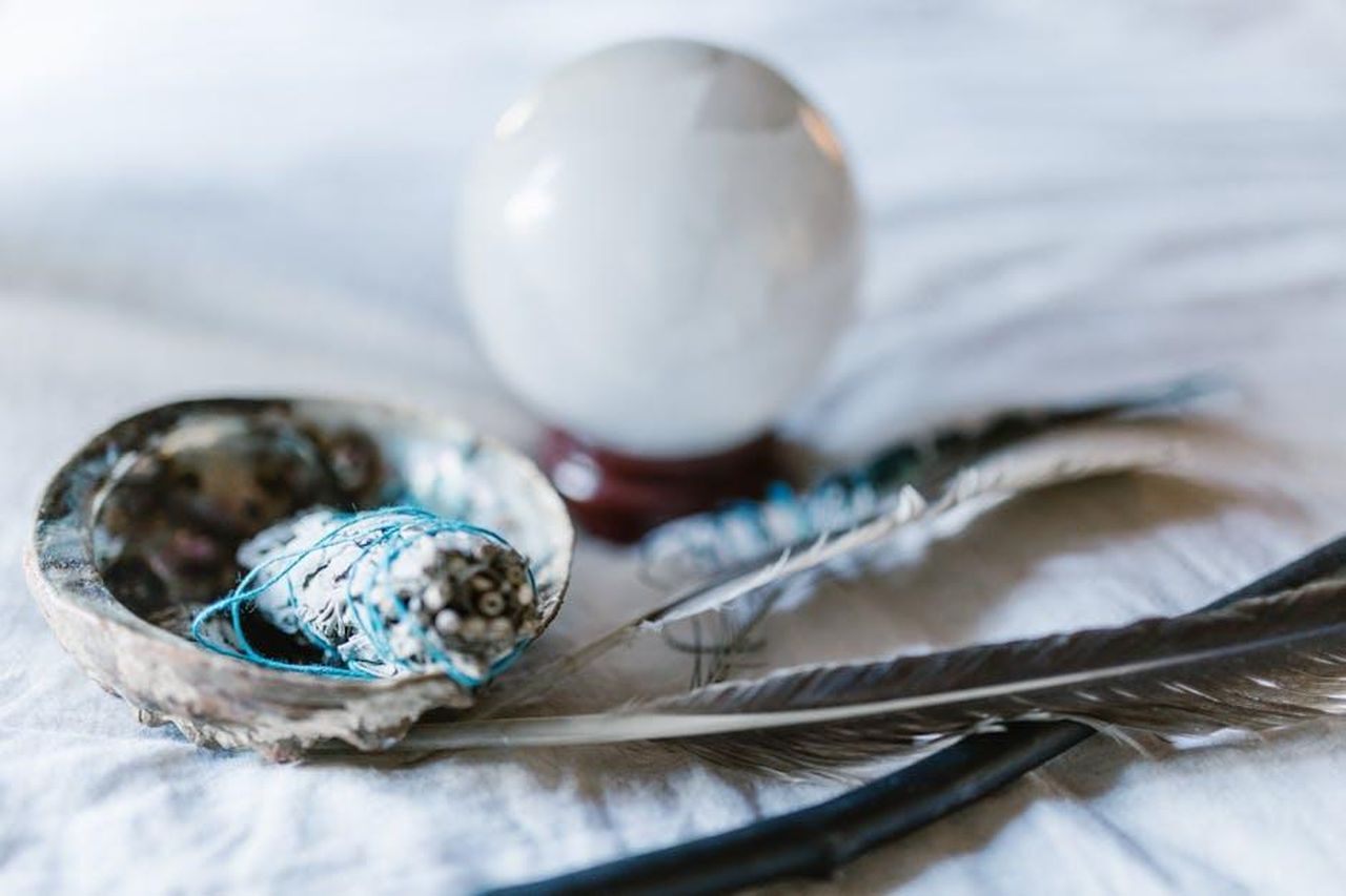 7_Acquario_fidatevi_della_vostra_intuizione_CpP0sHhAKt - Confidenze24 Source: RDNE Stock project - pexels - A spiritual arrangement featuring a crystal ball, sage bundle, and feathers, ideal for mystical themes.