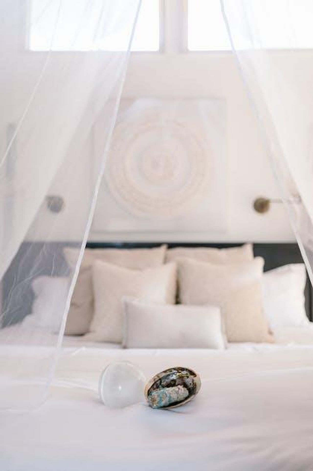 7_posto__Toro_aJEK0Sr9Hy - Confidenze24 Source: RDNE Stock project - pexels - A peaceful bedroom with white pillows and healing crystals creating a calming atmosphere.