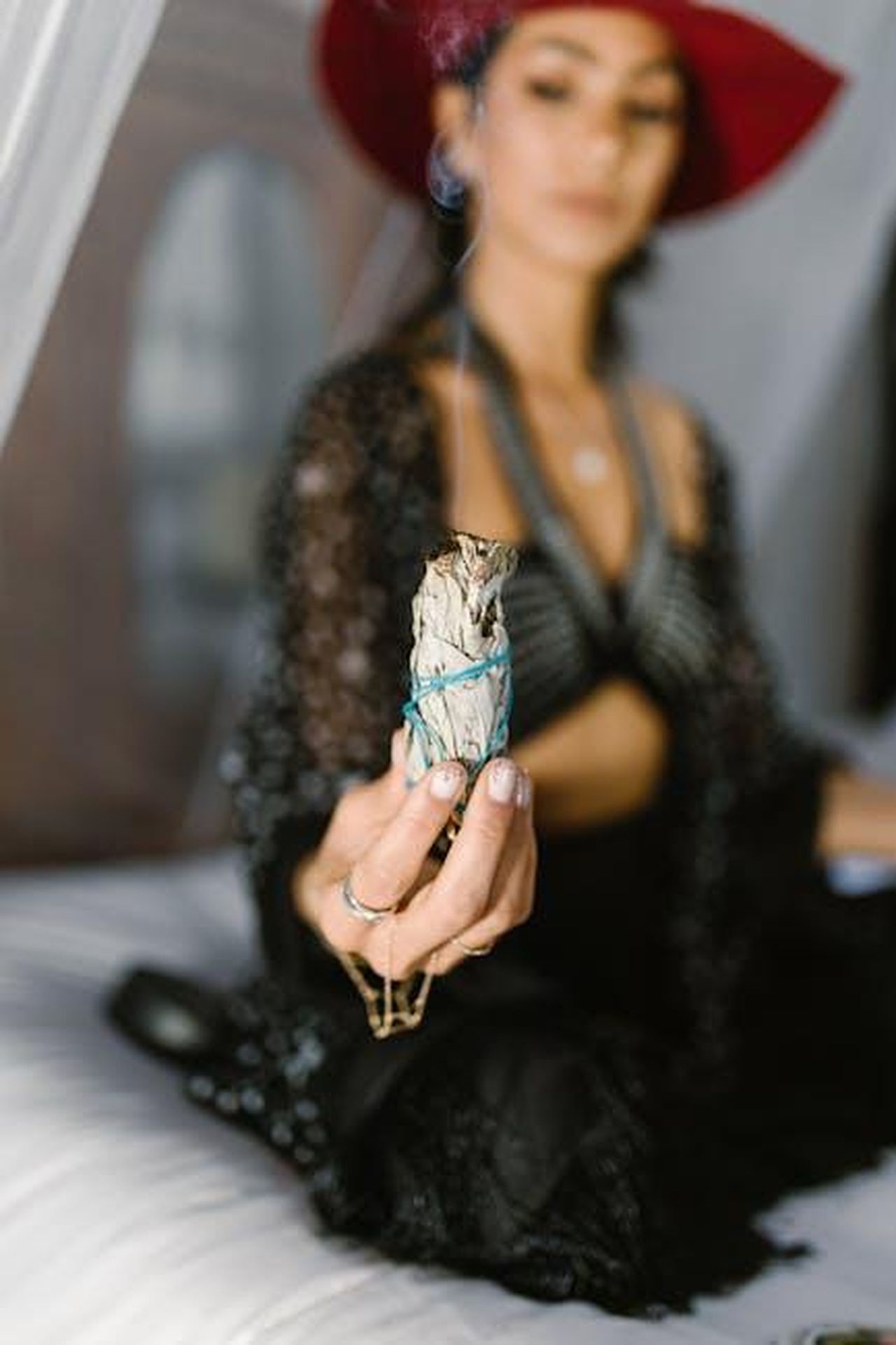8_Toro_pazienza_e_riflessione_j6DmcAw7zT - Confidenze24 Source: RDNE Stock project - pexels - A woman in mystical attire holding sage for a ritual indoors.