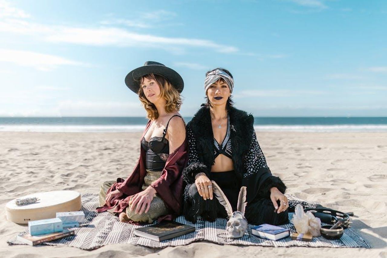 8_posto__Scorpione_eiqJV7ozmR - Confidenze24 Source: RDNE Stock project - pexels - Two women engaged in a mystical beach meditation session with crystals and tarot cards, embracing spirituality and the elements.