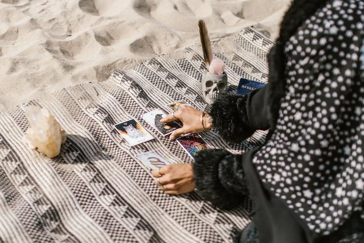 9_posto__Bilancia_hya1UpHbv5 - Confidenze24 Source: RDNE Stock project - pexels - A serene tarot reading on a beach, featuring crystals and a decorative skull.