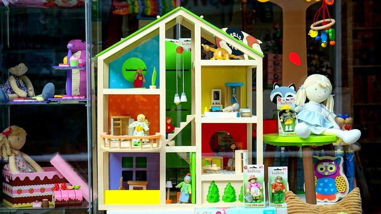 Accessori_e_vestiti_in_saldo_fino_al_40_39JI7mCnUb - Confidenze24 Source: Mike Bird - pexels - A vibrant dollhouse and stuffed toys displayed in a toy store window, perfect for children's play.