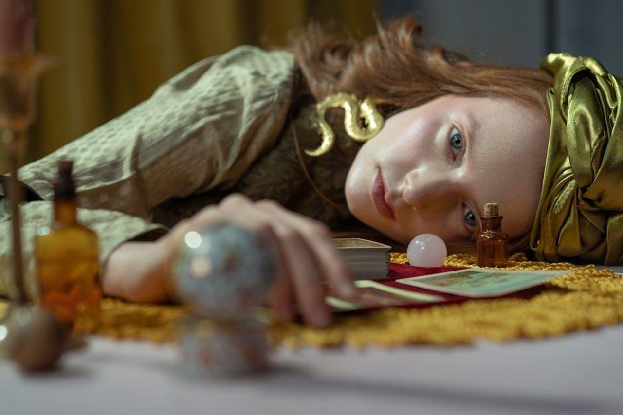 Acquario_creativit_e_comunicazione_xB6GM0asQr - Confidenze24 Source: cottonbro studio - pexels - Enigmatic woman lying with tarot cards and crystal ball in a mystical setting.