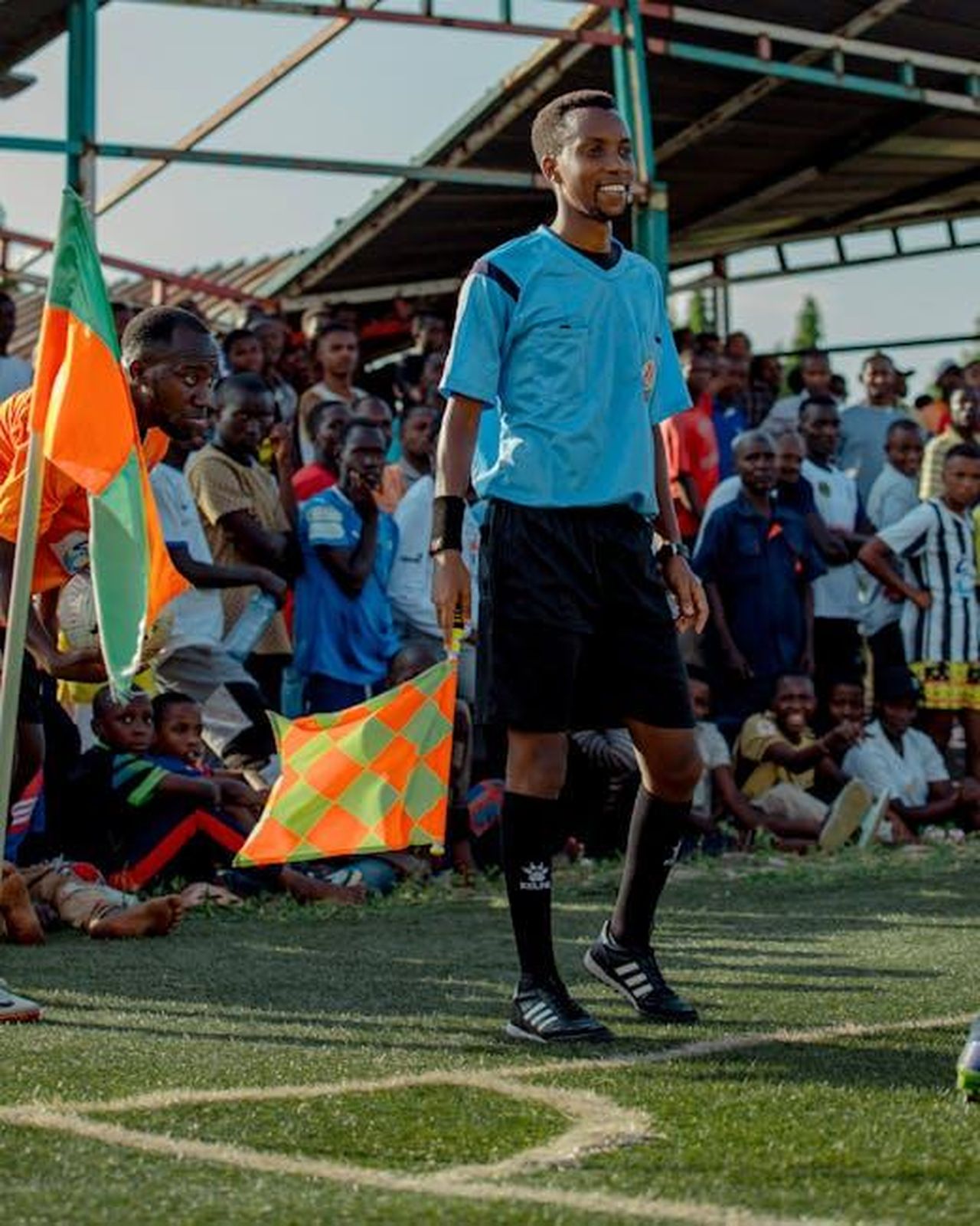 AllEzio_Scida_arbitra_il_Sig_Calzavara_4V0okMrYgG - Confidenze24 Source: Chris wade NTEZICIMPA - pexels - A soccer referee in blue stands by the field as a crowd watches an intense match.