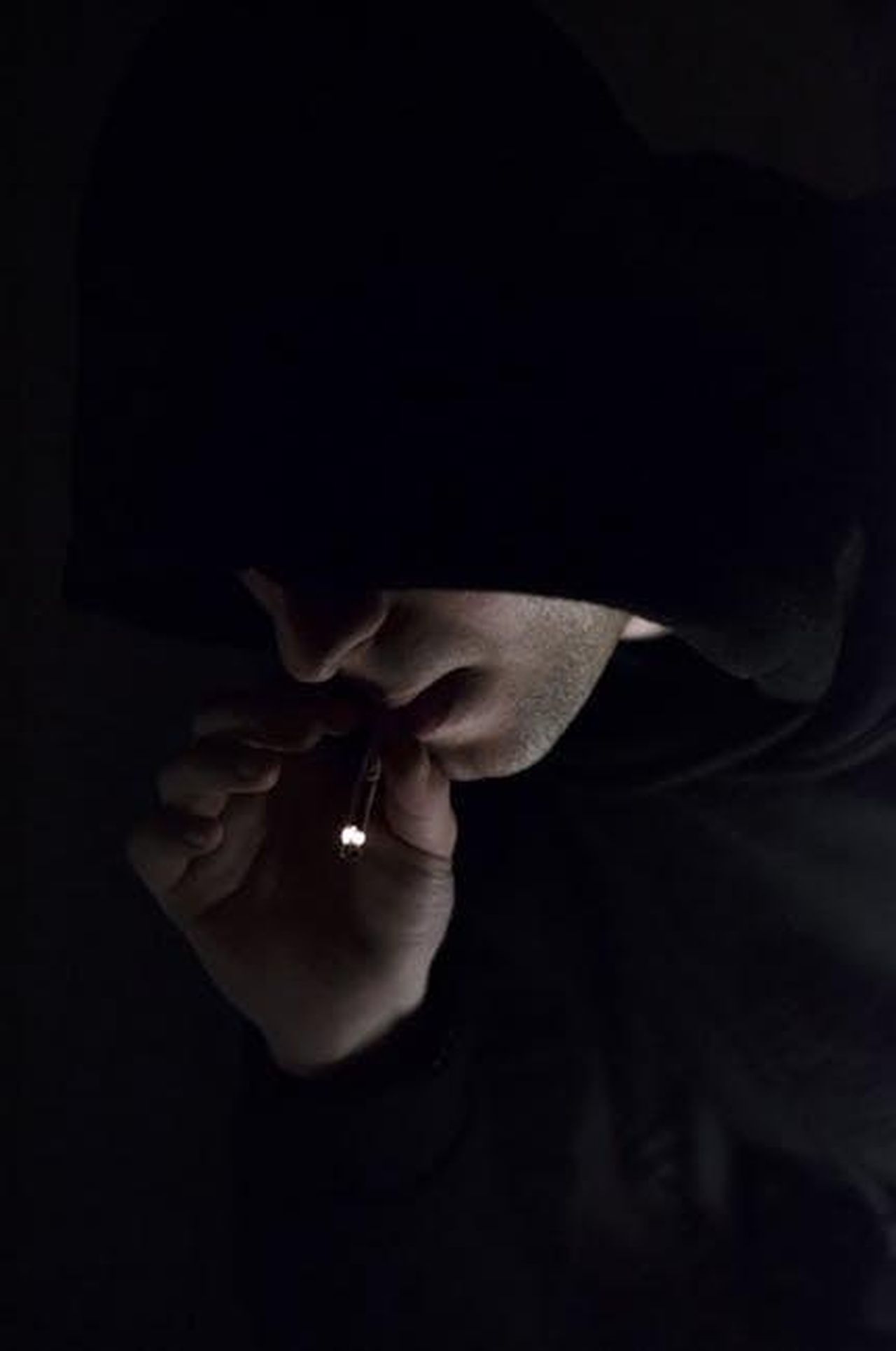 Alonso_ha_ordinato_a_tutti_discrezione_p3JaveC1aX - Confidenze24 Source: Julia Sakelli - pexels - A mysterious individual in a hoodie smoking in the dark, conveying a sense of enigma.