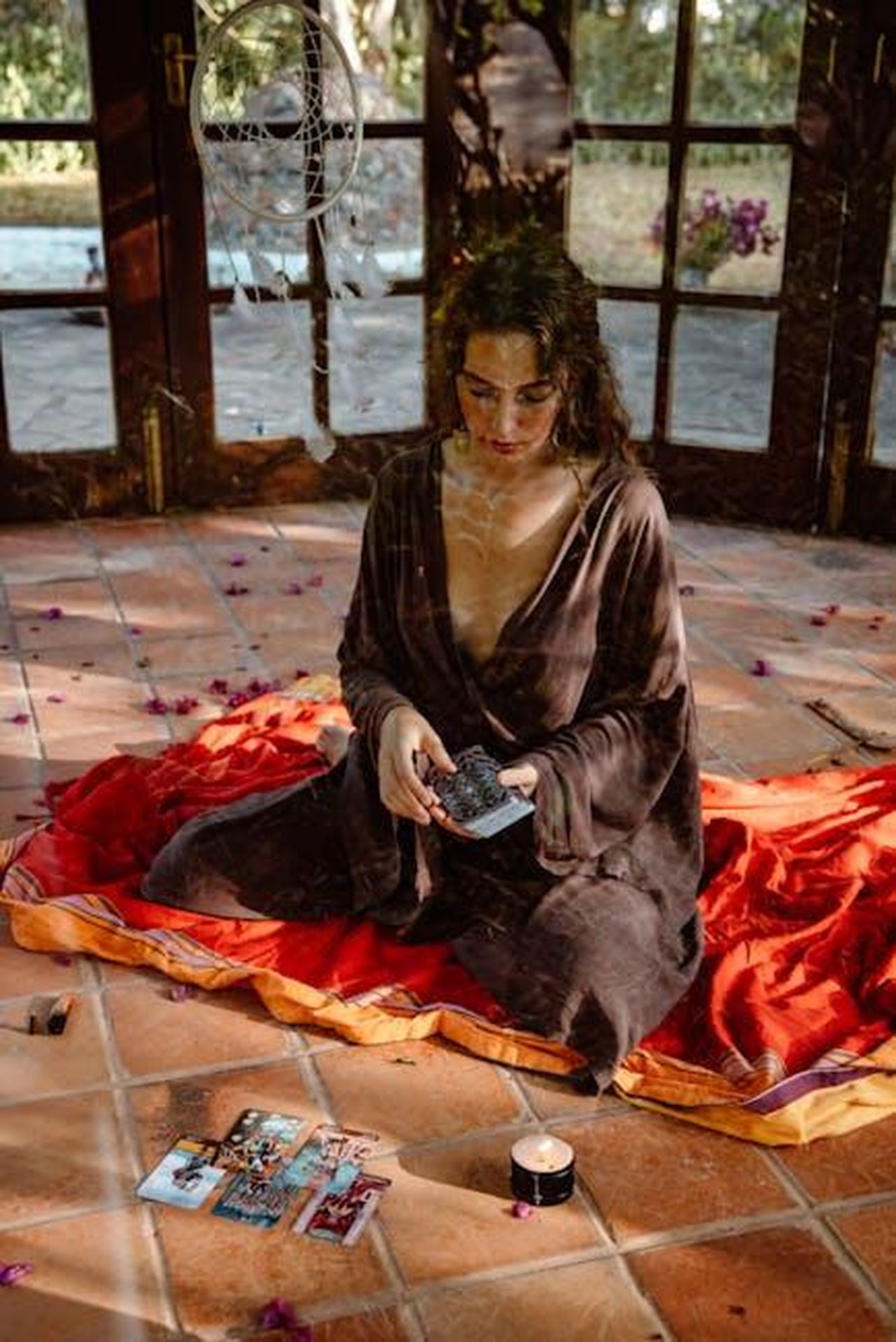 Analisi_della_vittoria_di_Timothee_Chalamet_YJIF6BtpaX - Confidenze24 Source: ROMAN ODINTSOV - pexels - A woman sitting indoors performing a tarot card reading with dreamy ambiance.
