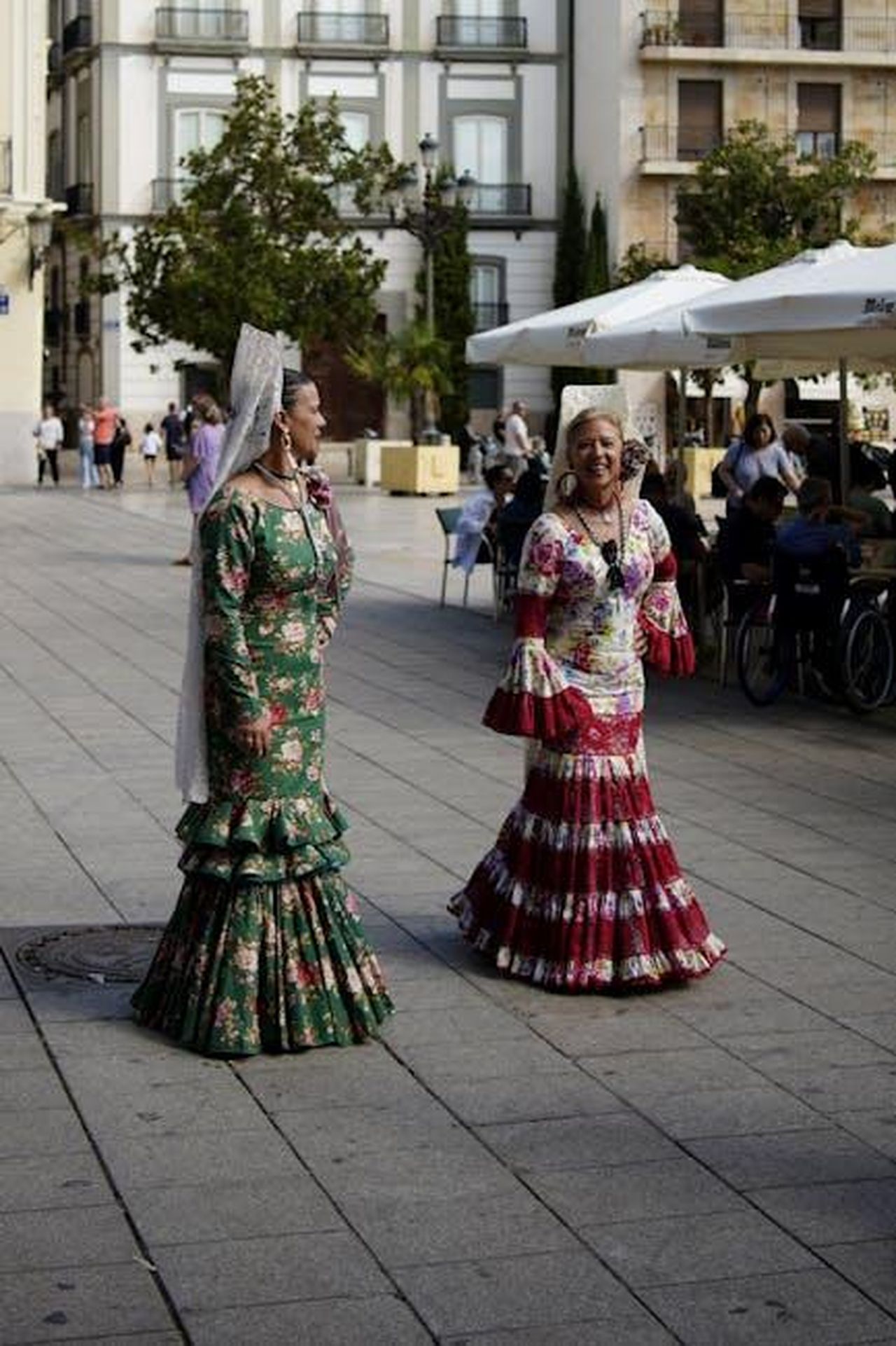 Angelo_lascia_il_programma_anticipazioni_Uomini_e_donne_marzo_w7HlaFEF5o - Confidenze24 Source: Giuseppe Di Maria - pexels - Two women wearing brightly colored flamenco dresses walk down a city plaza.