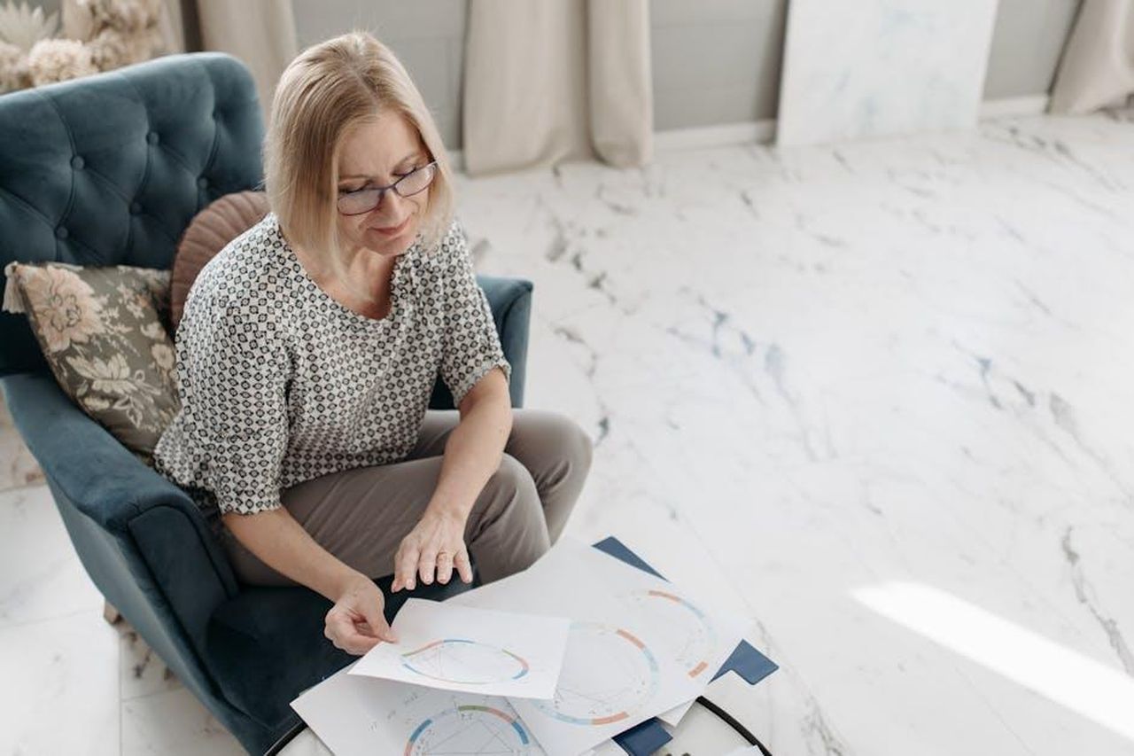 Ariete_opportunit_e_relazioni_T1C1CeQggc - Confidenze24 Source: Pavel Danilyuk - pexels - A woman carefully examines astrological charts while seated in a cozy indoor setting, showing focus and interest.