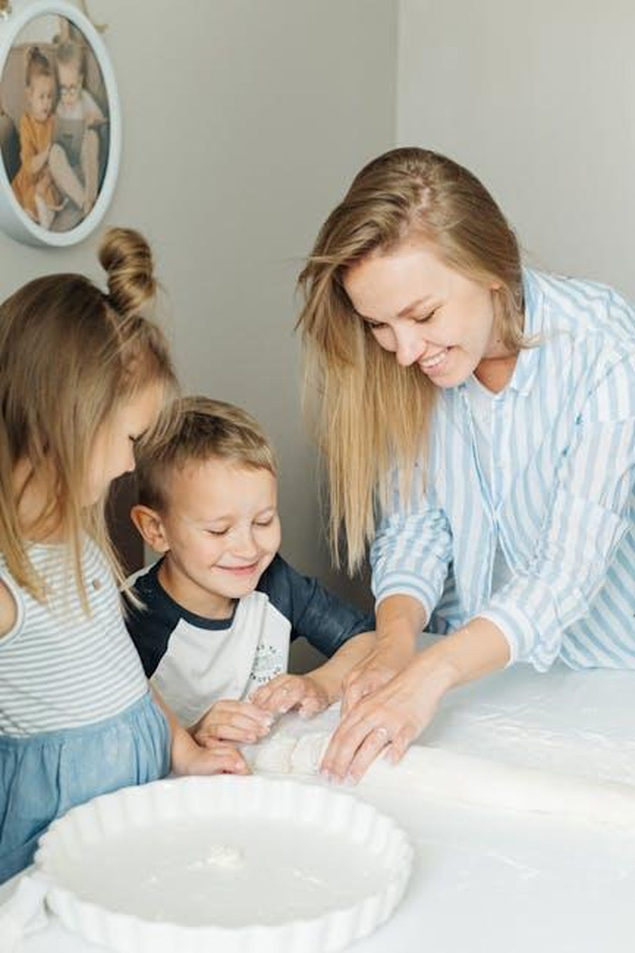 Attivit_di_cucina_con_i_bambini_E2EhF2Co9W - Confidenze24 Source: Ivan Samkov - pexels - A smiling mother and her two children enjoy quality time making dough together indoors.
