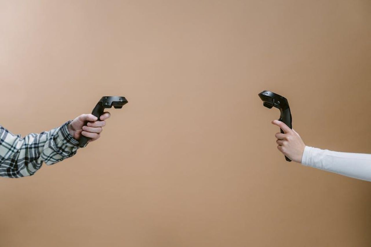 Beatrice_Luzzi_ha_puntato_il_dito_contro_la_concorrente_del_reality_DXfNMN7x9G - Confidenze24 Source: Tima Miroshnichenko - pexels - Hands holding game controllers against a brown backdrop, showcasing modern gaming technology.