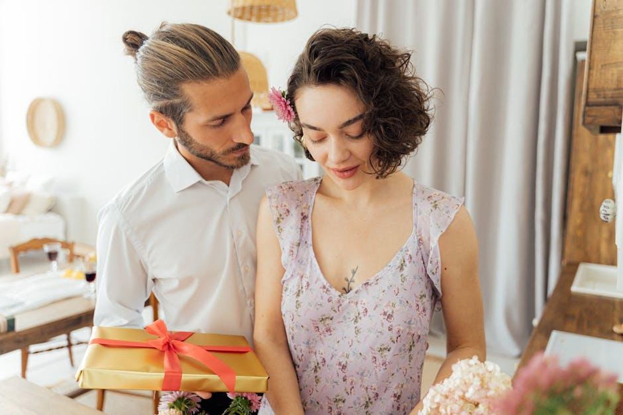Bella_come_sempre_Tess_ZomLq6GYiZ - Confidenze24 Source: Antoni Shkraba - pexels - A couple shares a sentimental moment with a gift in a cozy, well-lit indoor setting.