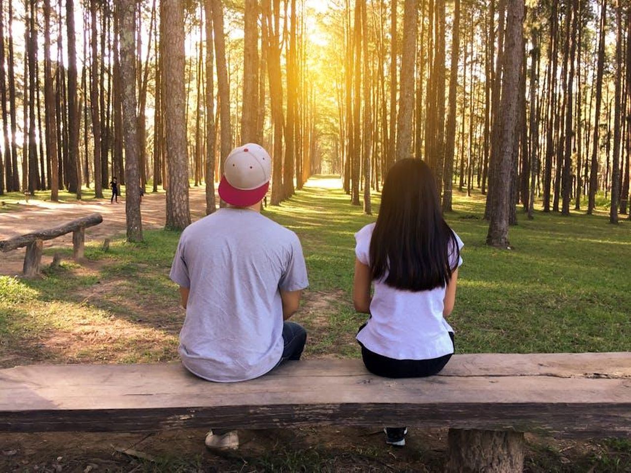 Ben_Affleck_pronto_a_tornare_a_frequentare_8rvktDW0Xp - Confidenze24 Source: Tirachard Kumtanom - pexels - A young couple sits on a bench surrounded by tall trees in a forest at sunset.