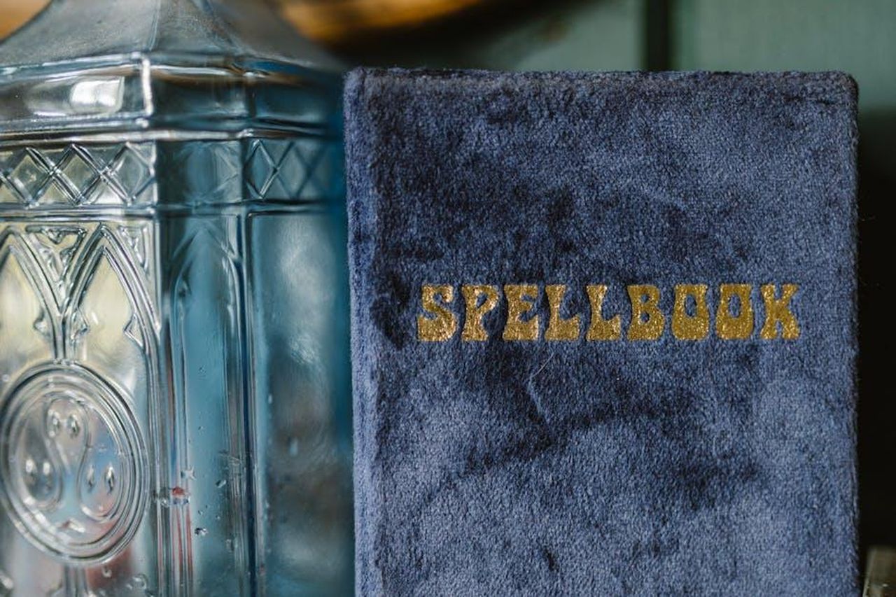 Bilancia_vibrazioni_positive_e_crescita_personale_jfW1gGFlzj - Confidenze24 Source: RDNE Stock project - pexels - A velvet-bound spellbook beside an ornamental glass bottle, evoking mystery and magic.