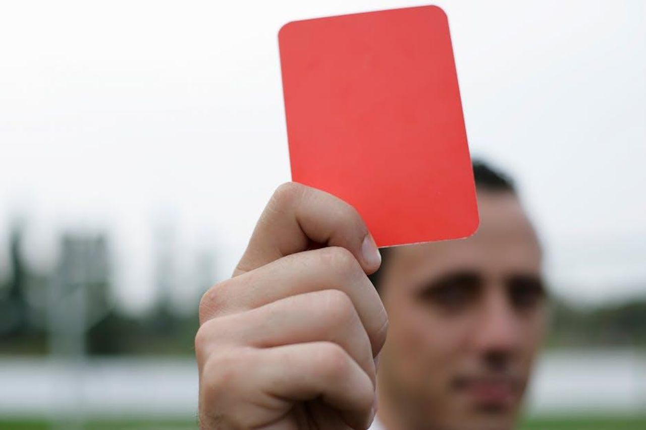 C_attesa_per_la_decisione_della_Covisoc_tZpC8CDfYJ - Confidenze24 Source: BOOM 💥 - pexels - Close-up of a referee holding a red card, signaling a penalty in a soccer match.