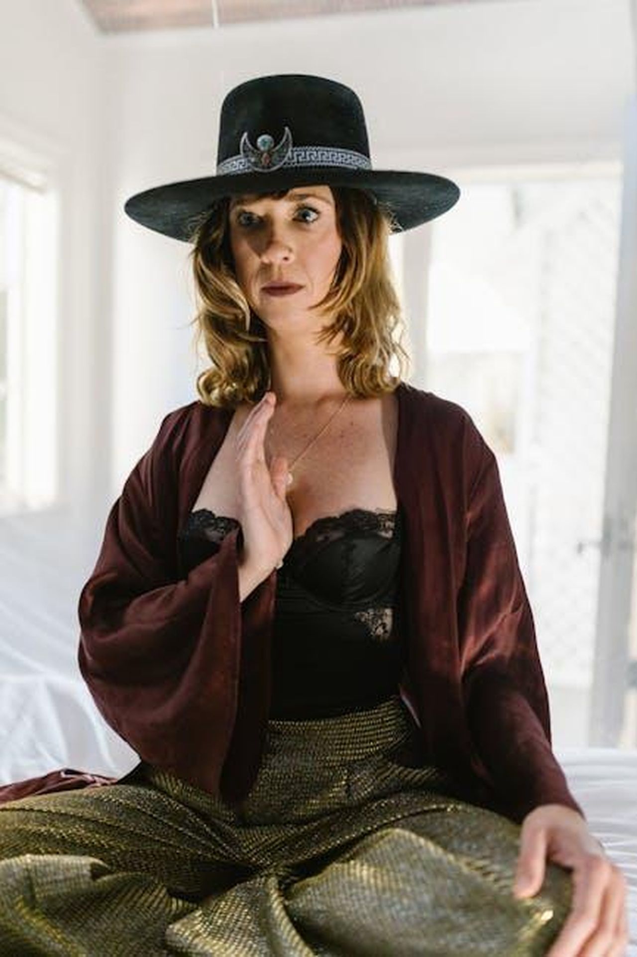 Cancro_empatia_e_intuizione_OWEjus9SkR - Confidenze24 Source: RDNE Stock project - pexels - A woman in elegant indoor setting strikes a thoughtful pose, wearing a wide-brim hat and fashionable outfit.