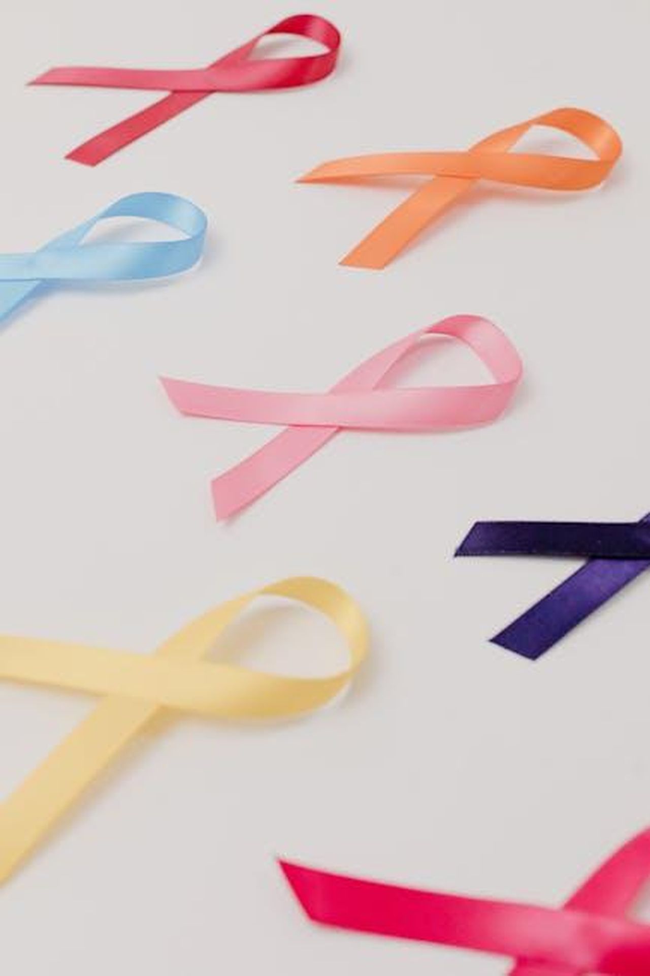 Cancro_gA41i46Syd - Confidenze24 Source: Tara Winstead - pexels - Vibrant awareness ribbons representing various causes on a white surface.