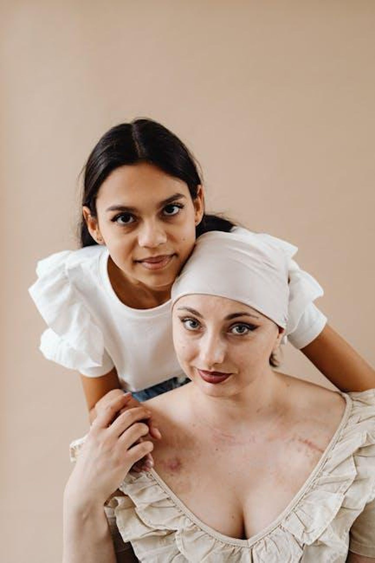 Cancro_sensibilit_in_amore_1jBJHuyuf8 - Confidenze24 Source: Photo By: Kaboompics.com - pexels - Portrait of a supportive friend comforting an ill woman with visible scars and a headscarf.