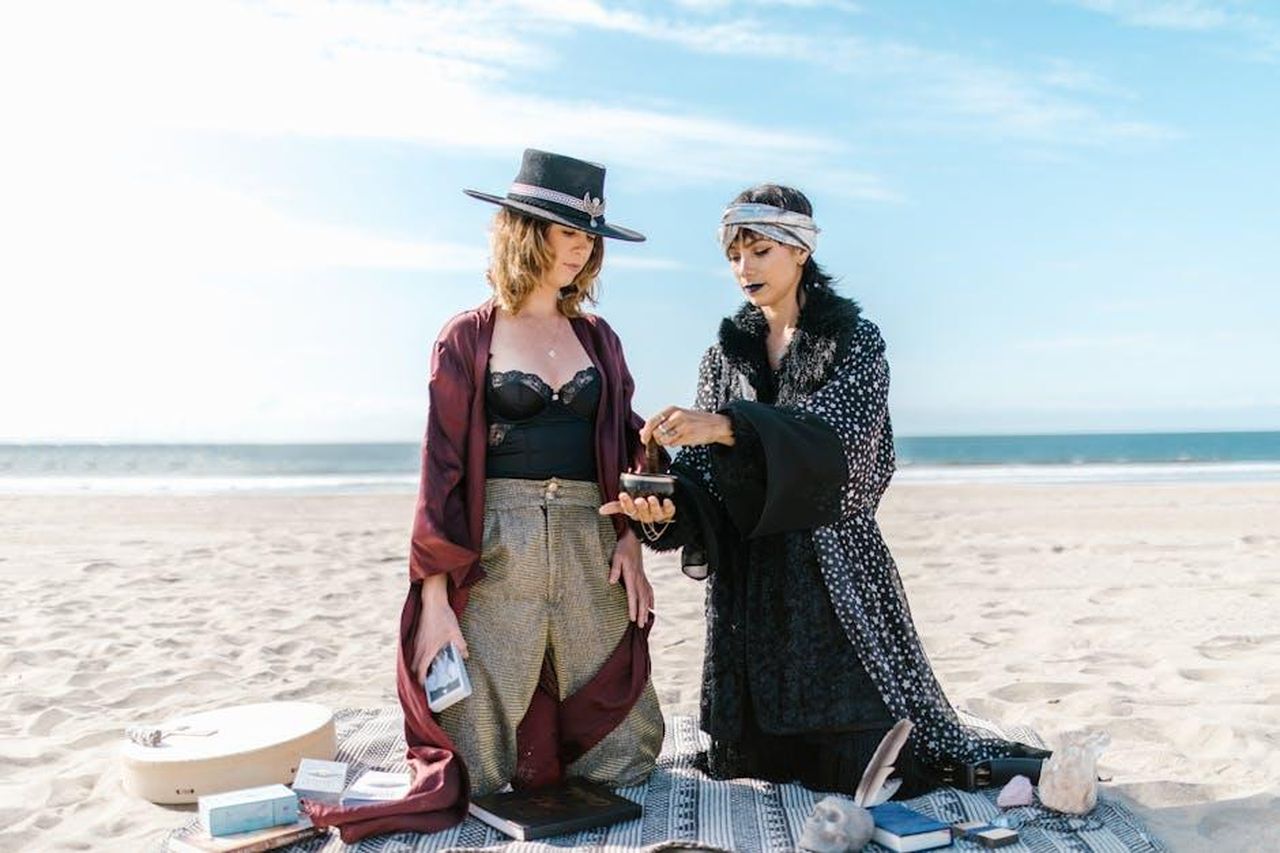 Capricorno_buoni_sentimenti_ma_difficolt_a_manifestarli_D15BUr2mKh - Confidenze24 Source: RDNE Stock project - pexels - Two women engage in a spiritual ritual on a sunny beach, surrounded by crystals.