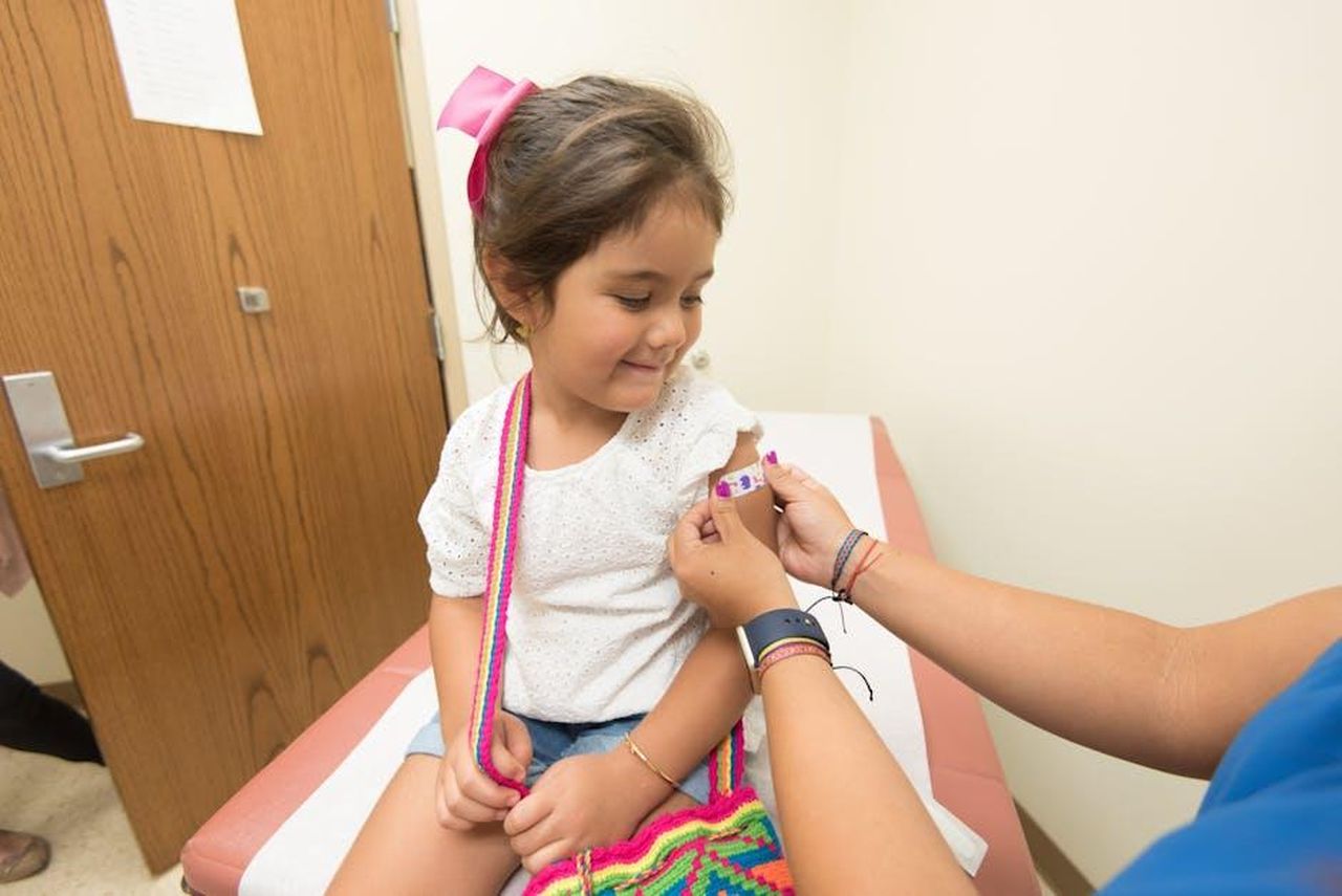 Chi_deve_considerare_un_richiamo_IdJDb9MbV9 - Confidenze24 Source: CDC - pexels - A cheerful young girl receives a band-aid after a vaccination at a clinic.