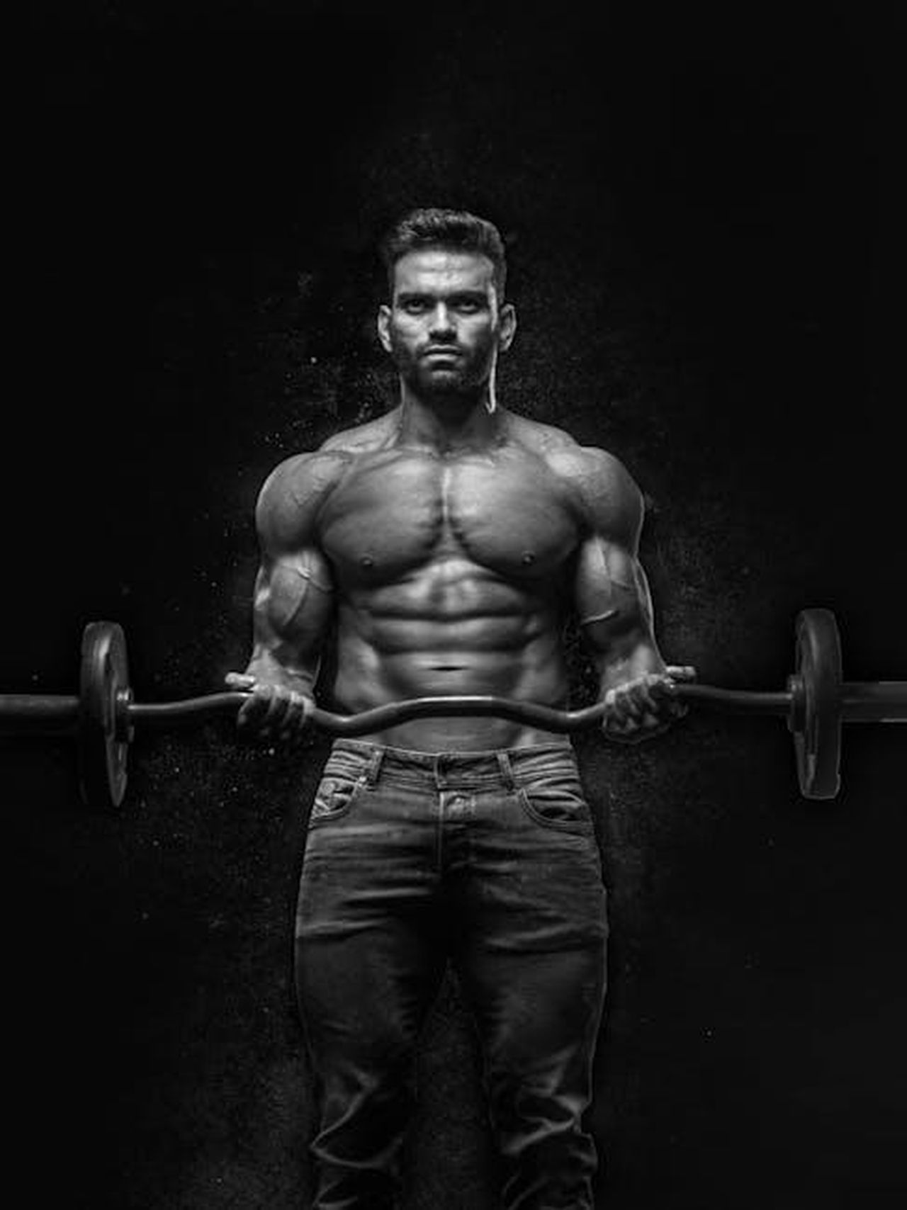 Ci_vorr_un_anno_per_ottenere_il_risultato_desiderato_6j2iKwkGLo - Confidenze24 Source: Anush Gorak - pexels - Black and white portrait of a muscular man lifting weights, showcasing strength and fitness.