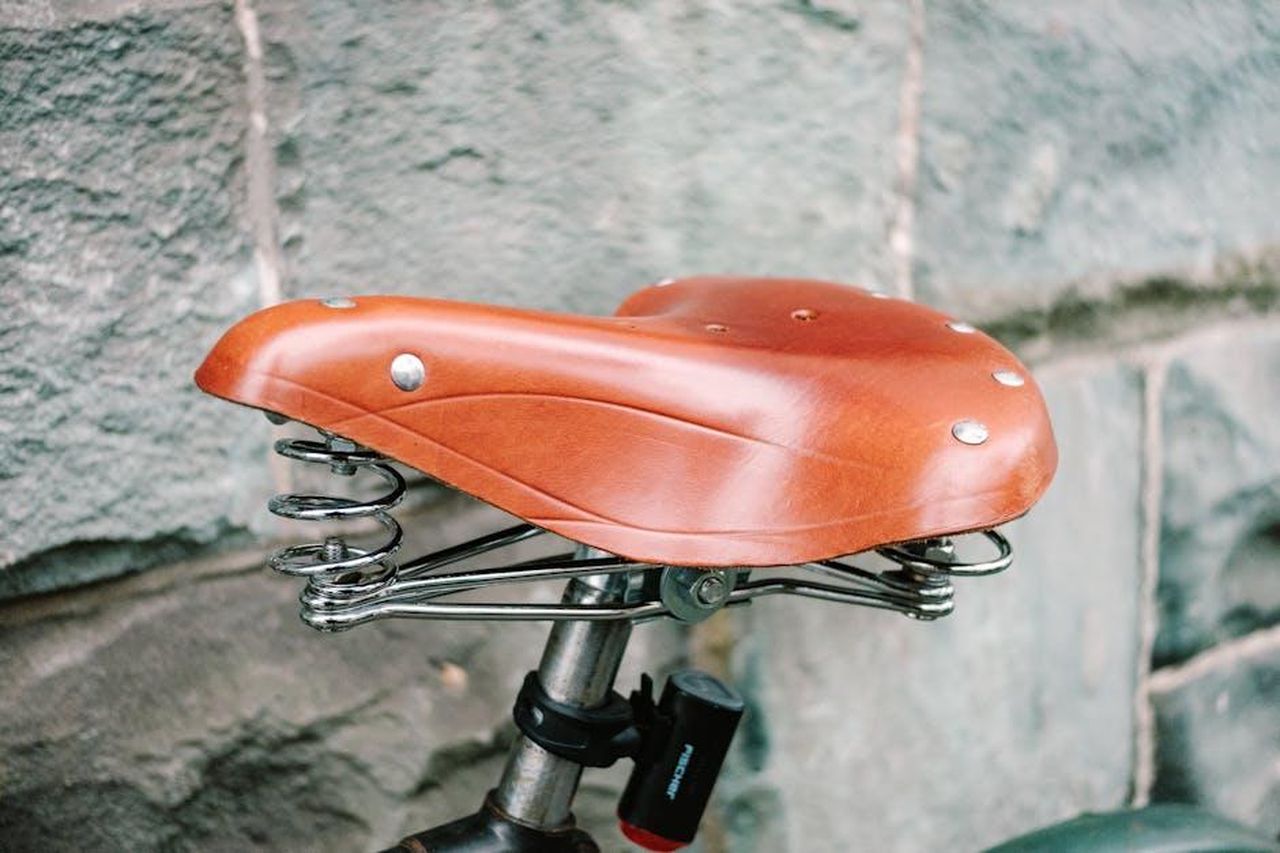 Come_Funzionano_i_Deodoranti_Ricaricabili_dT8nYMVWrK - Confidenze24 Source: Markus Winkler - pexels - Close-up of a vintage leather bicycle seat with metal springs against a stone wall.