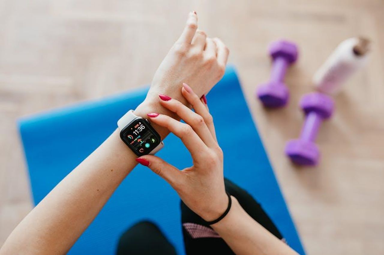 Commenti_e_Reazioni_al_Rinnovo_di_Tracker_xT4fOYvSTf - Confidenze24 Source: Photo By: Kaboompics.com - pexels - A woman checks fitness data on her smartwatch during a workout at home.