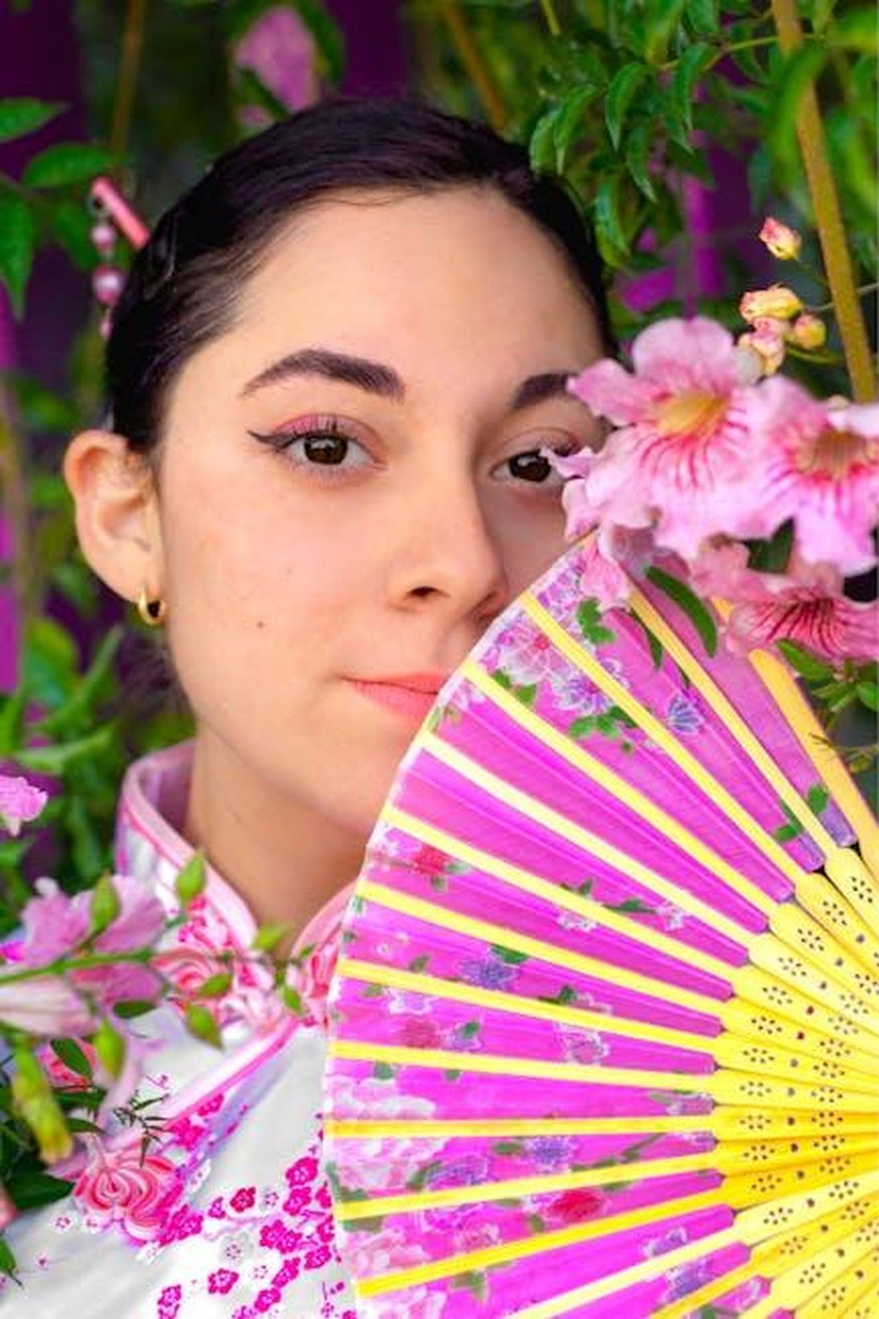 Commenti_e_reazioni_dei_fan_ieZwi9OWfX - Confidenze24 Source: Azahel Calzada De La Luz - pexels - A woman in traditional attire elegantly poses with a vibrant floral fan, surrounded by pink blossoms.