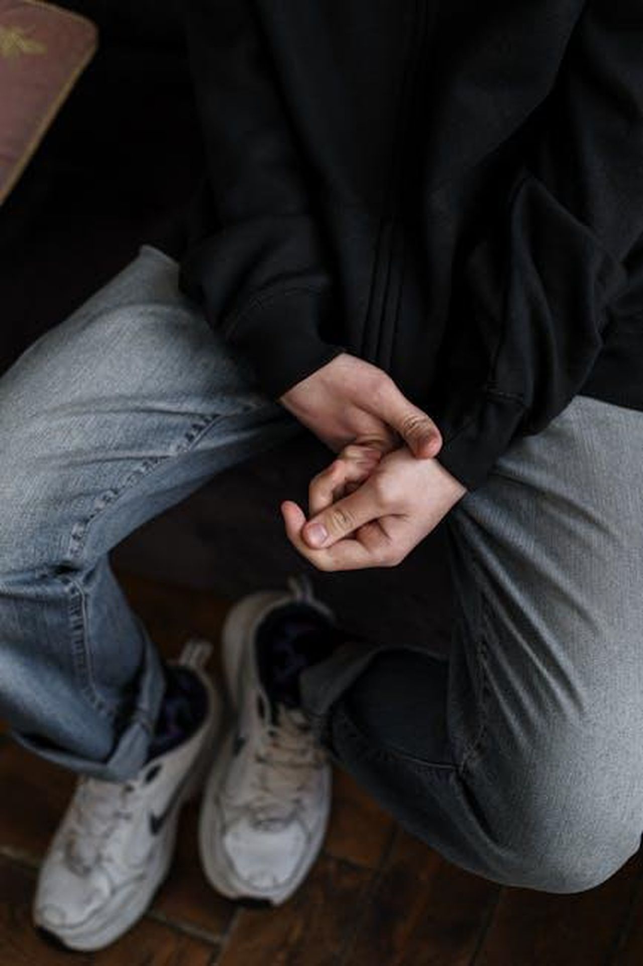 Cosa_emnonem_dire_agli_adolescenti_KlS7RoA7lg - Confidenze24 Source: cottonbro studio - pexels - A young man in casual attire sitting with hands clasped, expressing contemplation.
