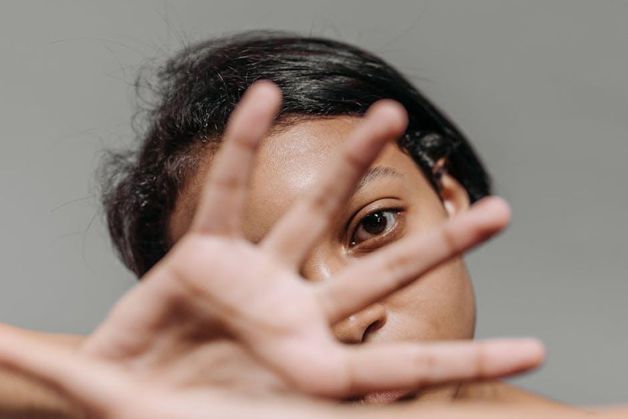 Creare_il_look_perfetto_per_un_artista_pqzwxqeMst - Confidenze24 Source: ROCKETMANN TEAM - pexels - Intimate portrait of a woman partially covering her face with her hand against a gray background.