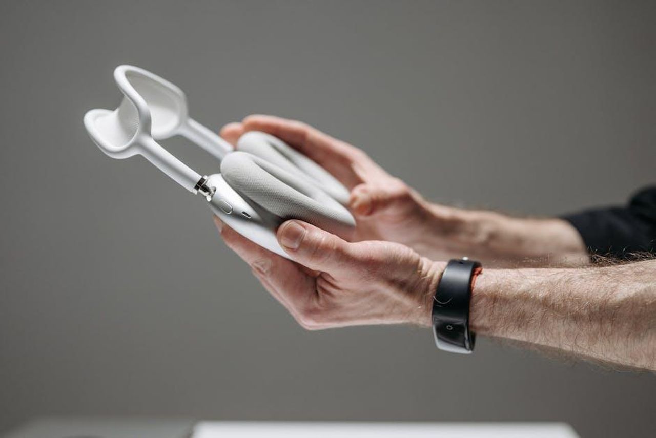 Cristiano_Malgiolgio_allattacco_di_Mogol_LYFU2sCkZH - Confidenze24 Source: Pavel Danilyuk - pexels - Close-up of hands holding white wireless over-ear headphones against a grey background.