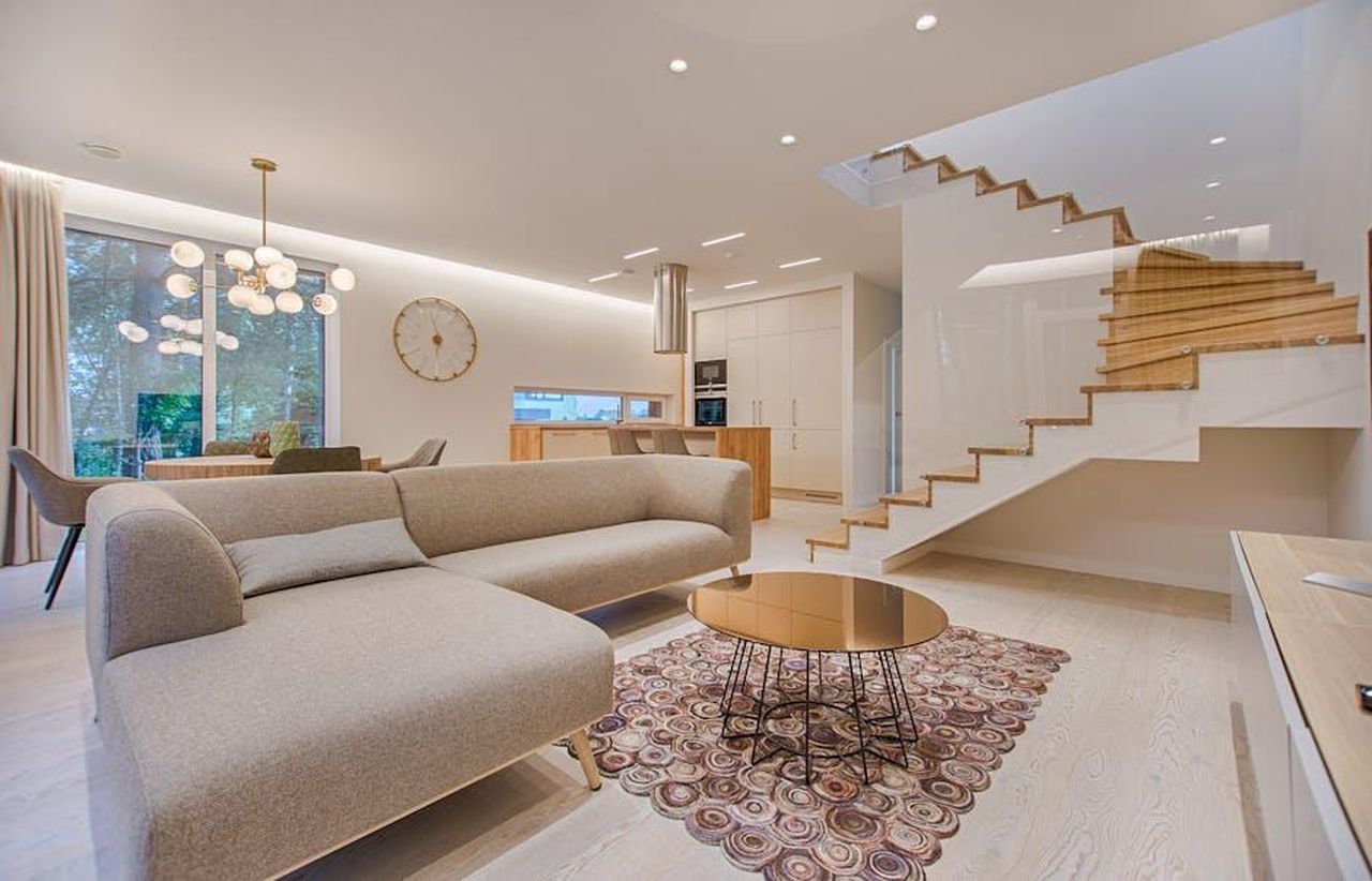 Critiche_a_Stacey_Solomon_RZVBwyYNJN - Confidenze24 Source: Vecislavas Popa - pexels - Contemporary living room with neutral tones, a sleek sofa, and elegant wooden staircase.