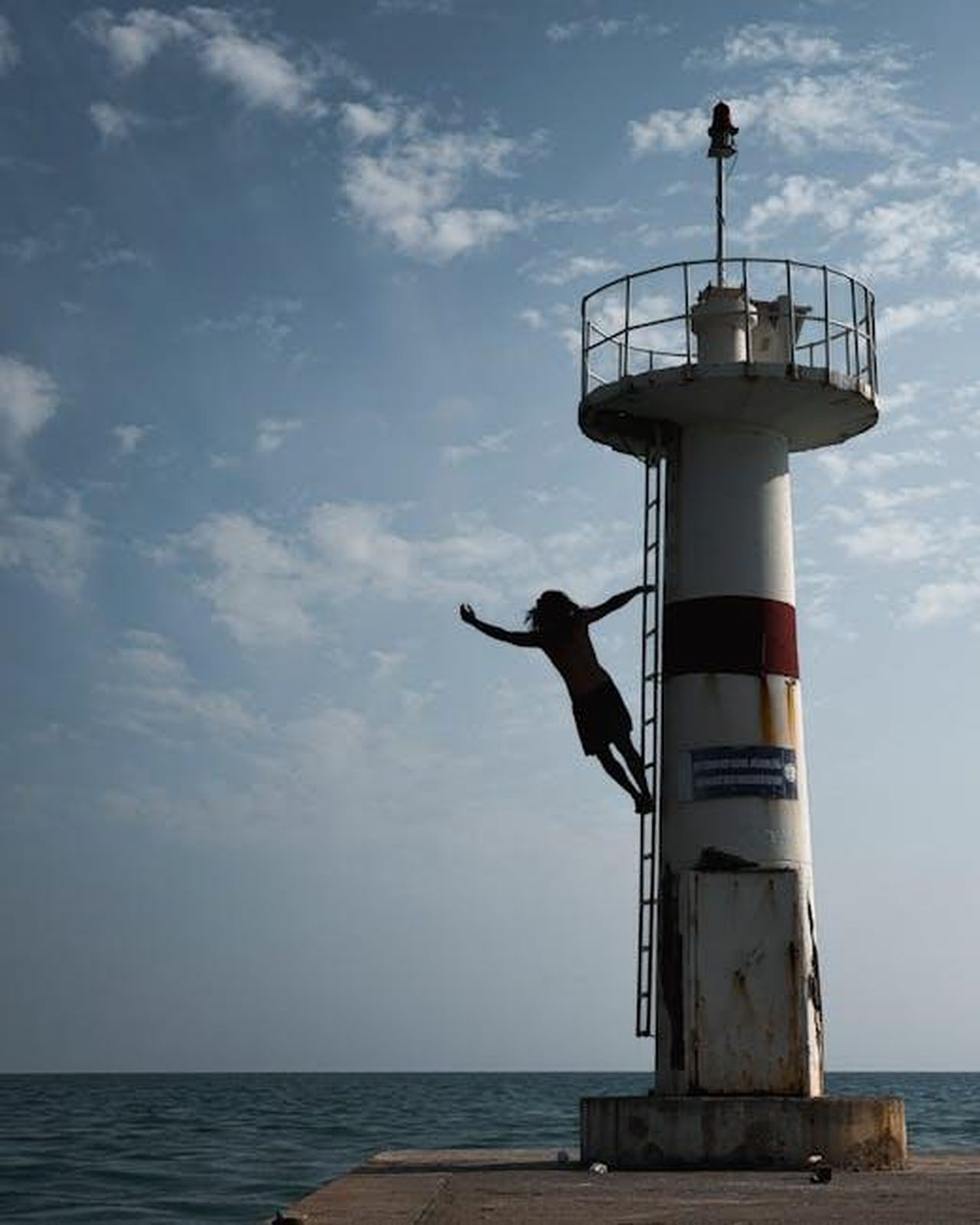 Devo_fare_un_salto_nel_vuoto_99eI6993IU - Confidenze24 Source: Ahmet Yüksek ✪ - pexels - Silhouette of a person jumping from a lighthouse over the ocean under a cloudy sky.