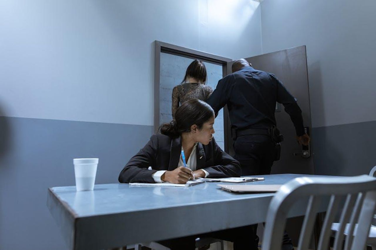 Dilek_denuncia_Yeim_ma__costretta_a_ritirare_laccusa_per_non_rivelare_la_gravidanza_fy0RF0YWk0 - Confidenze24 Source: RDNE Stock project - pexels - Police officer escorting suspect as lawyer observes during interrogation.