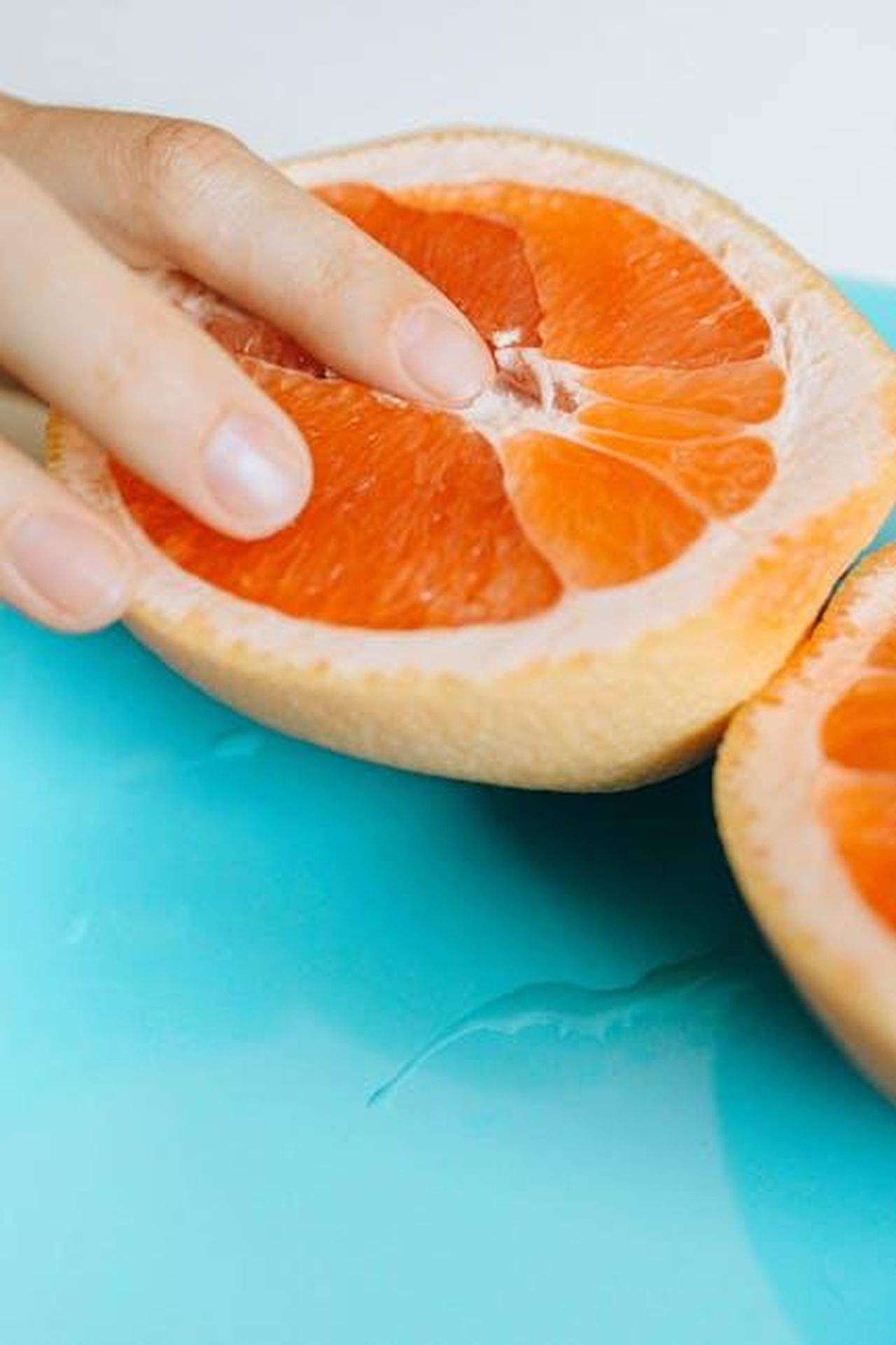 Educare_i_figli_sulla_differenza_tra_pornografia_e_realt_e4oYlxosyh - Confidenze24 Source: Nataliya Vaitkevich - pexels - Artistic shot of a hand touching grapefruit, symbolizing sensuality.