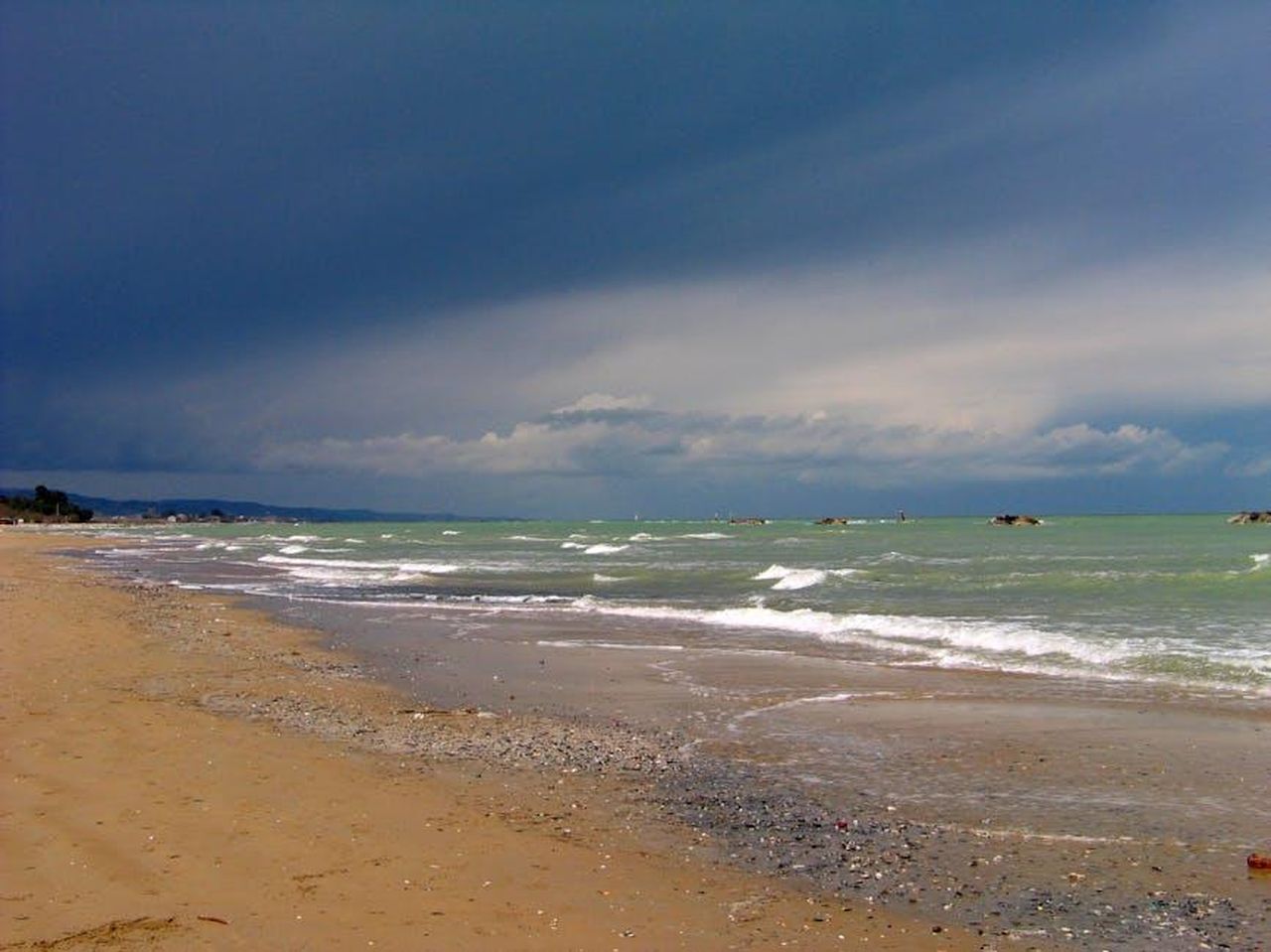 Eliminazione_shock_e_reazioni_nella_Casa_dZFU31dalD - Confidenze24 Source: Roman Biernacki - pexels - Captivating view of a sandy beach under a dramatic stormy sky with waves crashing ashore.