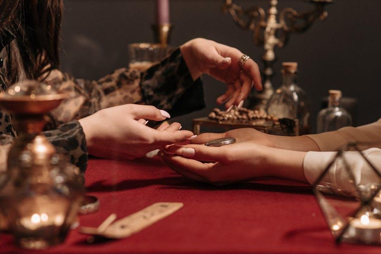 Fortuna_in_calo_per_Scorpione_iFXz8xOouI - Confidenze24 Source: Pavel Danilyuk - pexels - A fortune teller delicately reading a client's palm in a mystic setting with enchanting ambiance.