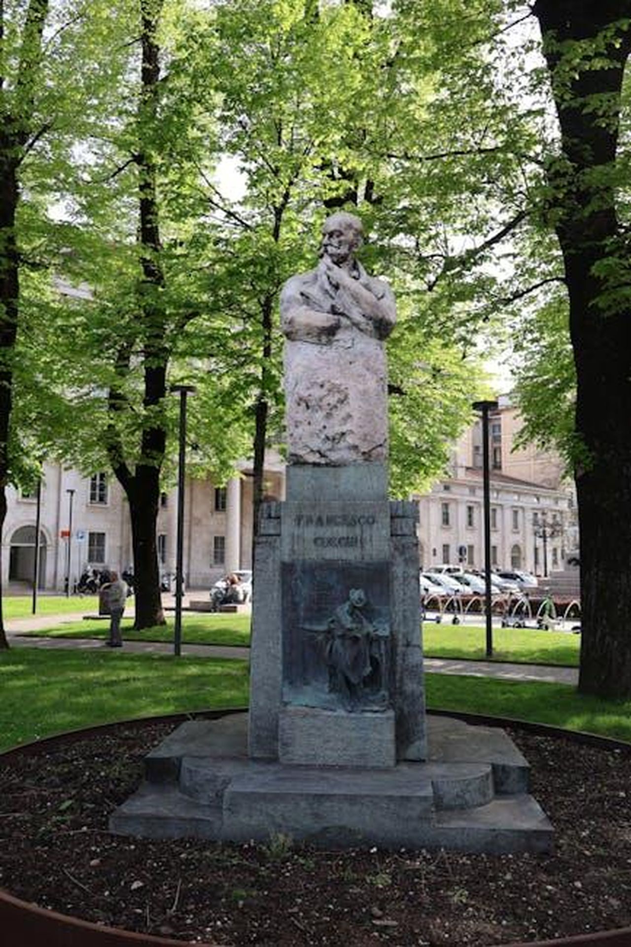 Francesco_Gabbani_e_Tricarico__Io_sono_Francesco_usXq3ZbYk9 - Confidenze24 Source: Travel Photographer - pexels - A stone sculpture in a lush park in Bergamo, Italy, surrounded by vibrant greenery.