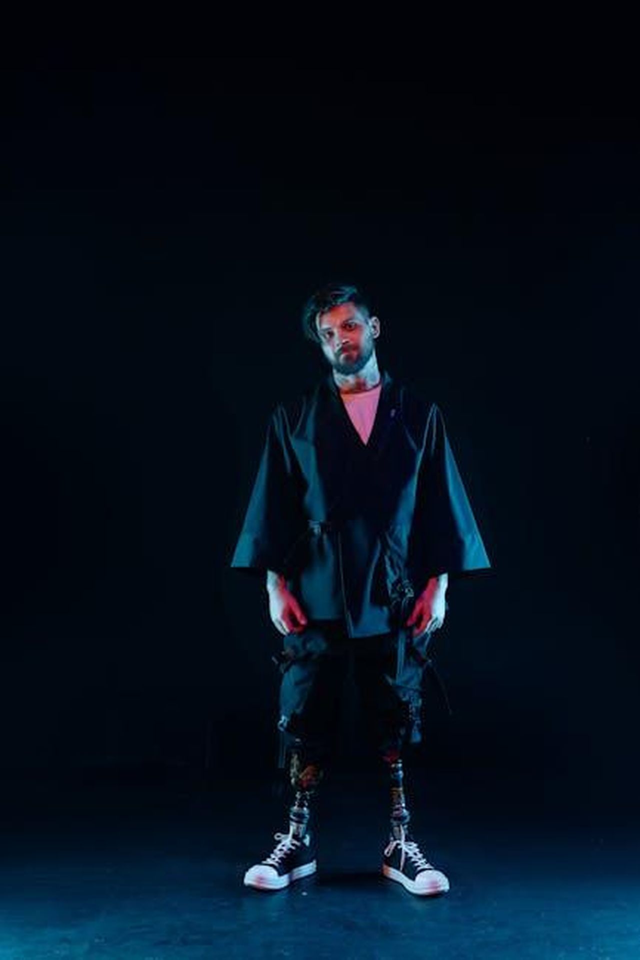 Futuro_nel_teatro_cinema_e_TV_7I1nIeHkwq - Confidenze24 Source: cottonbro studio - pexels - Portrait of a man in futuristic fashion with prosthetic legs, showcasing style and resilience.