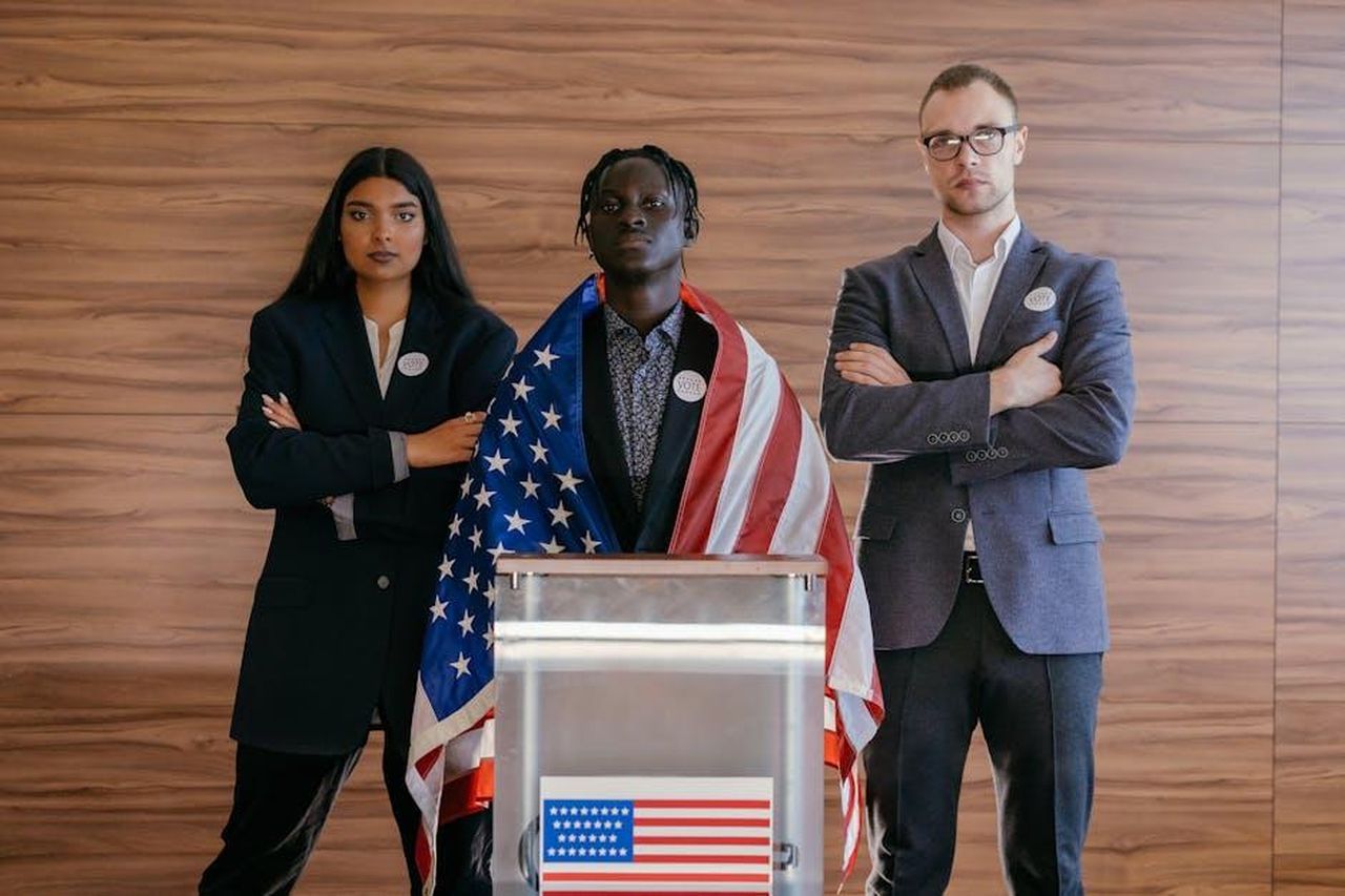 Futuro_politico_di_Kamala_Harris_iKJVRYiyT6 - Confidenze24 Source: Mikhail Nilov - pexels - Diverse group of political candidates standing with American flag at voting podium.