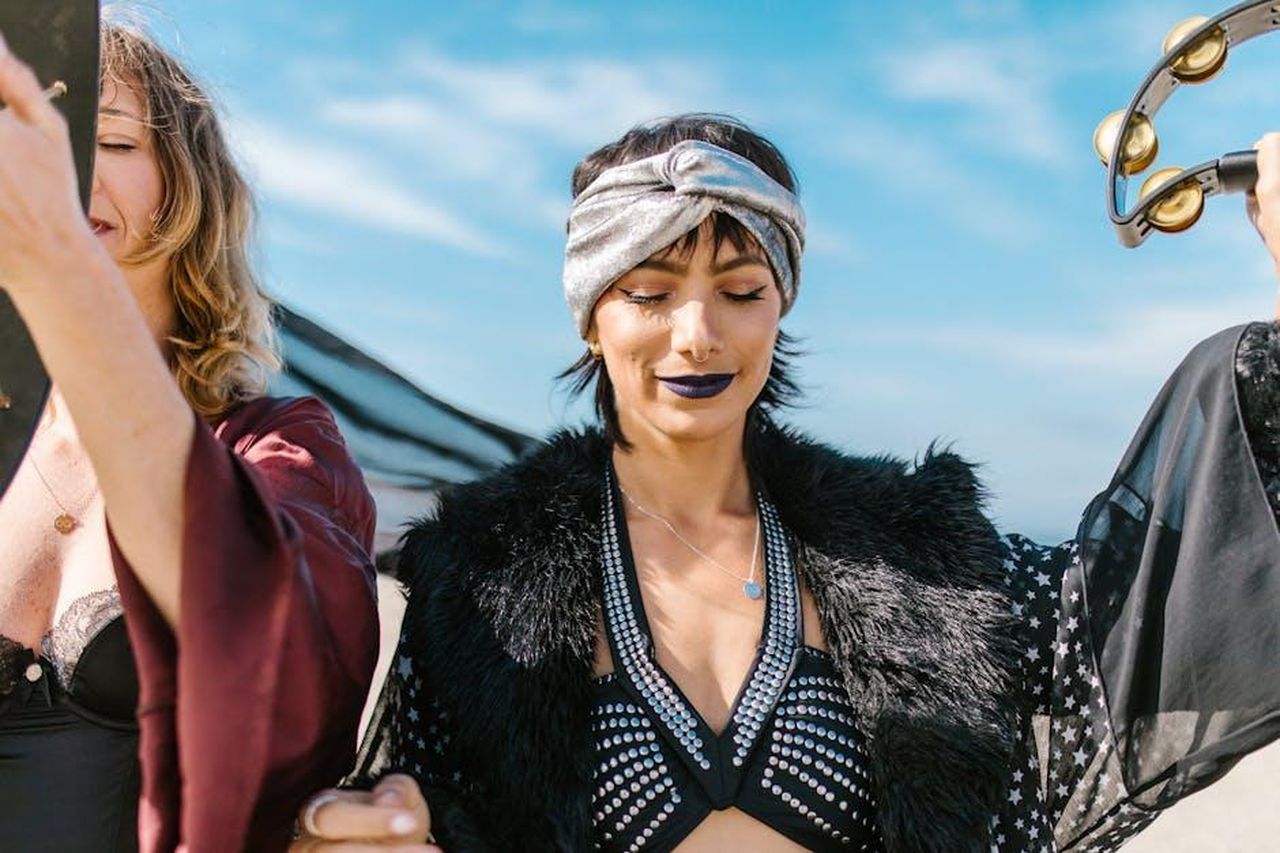 Gemelli_21_maggio__21_giugno_BxwrP4TAL3 - Confidenze24 Source: RDNE Stock project - pexels - Two women enjoying a bohemian style gathering outdoors with tambourines and unique fashion elements.