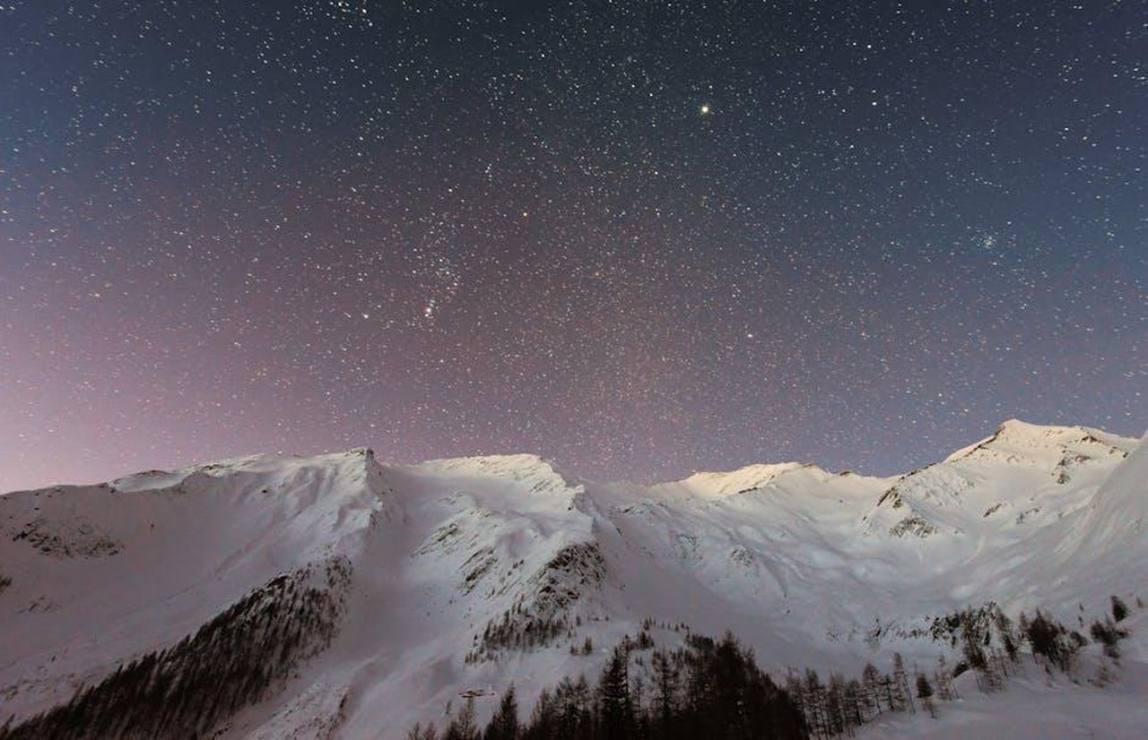 Gemelli__Opportunit_e_connessioni_BcoaJYFeMj - Confidenze24 Source: eberhard grossgasteiger - pexels - A breathtaking view of snow-capped mountains under a starry night sky, capturing the beauty of winter outdoors.