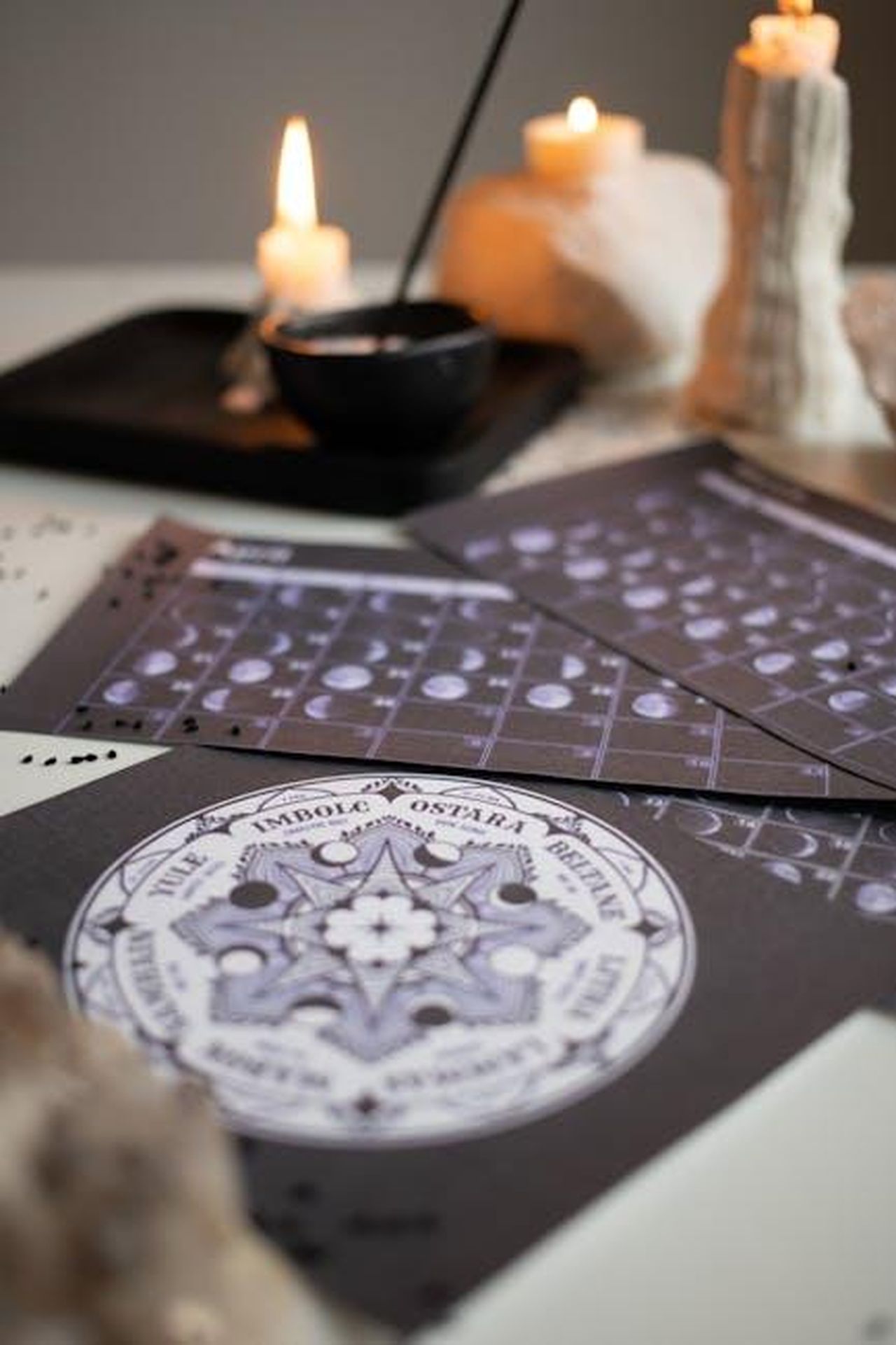 Gemelli_giornata_proattiva_e_serena_xgsJUif37W - Confidenze24 Source: Monstera Production - pexels - A mystical setup with candles, moon phase calendars, and spiritual symbols on a table.