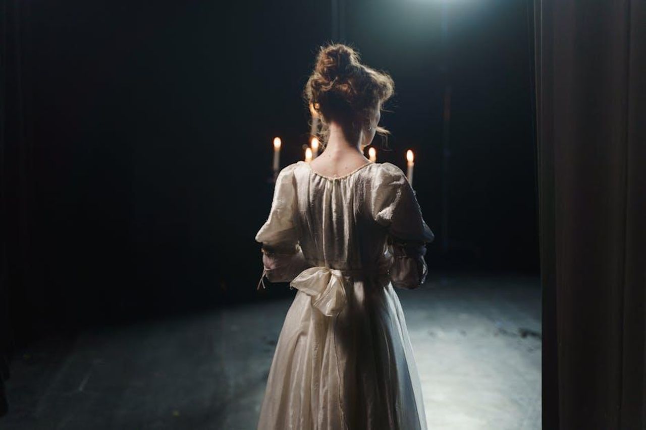 Grande_Fratello_eliminati_e_nomination_del_20_febbraio_2025_Ci_saranno_concorrenti_eliminati_I_sondaggi_RJoGma0gAk - Confidenze24 Source: cottonbro studio - pexels - An actress in a white dress stands backstage in dim lighting, enhancing a classic theatrical atmosphere.